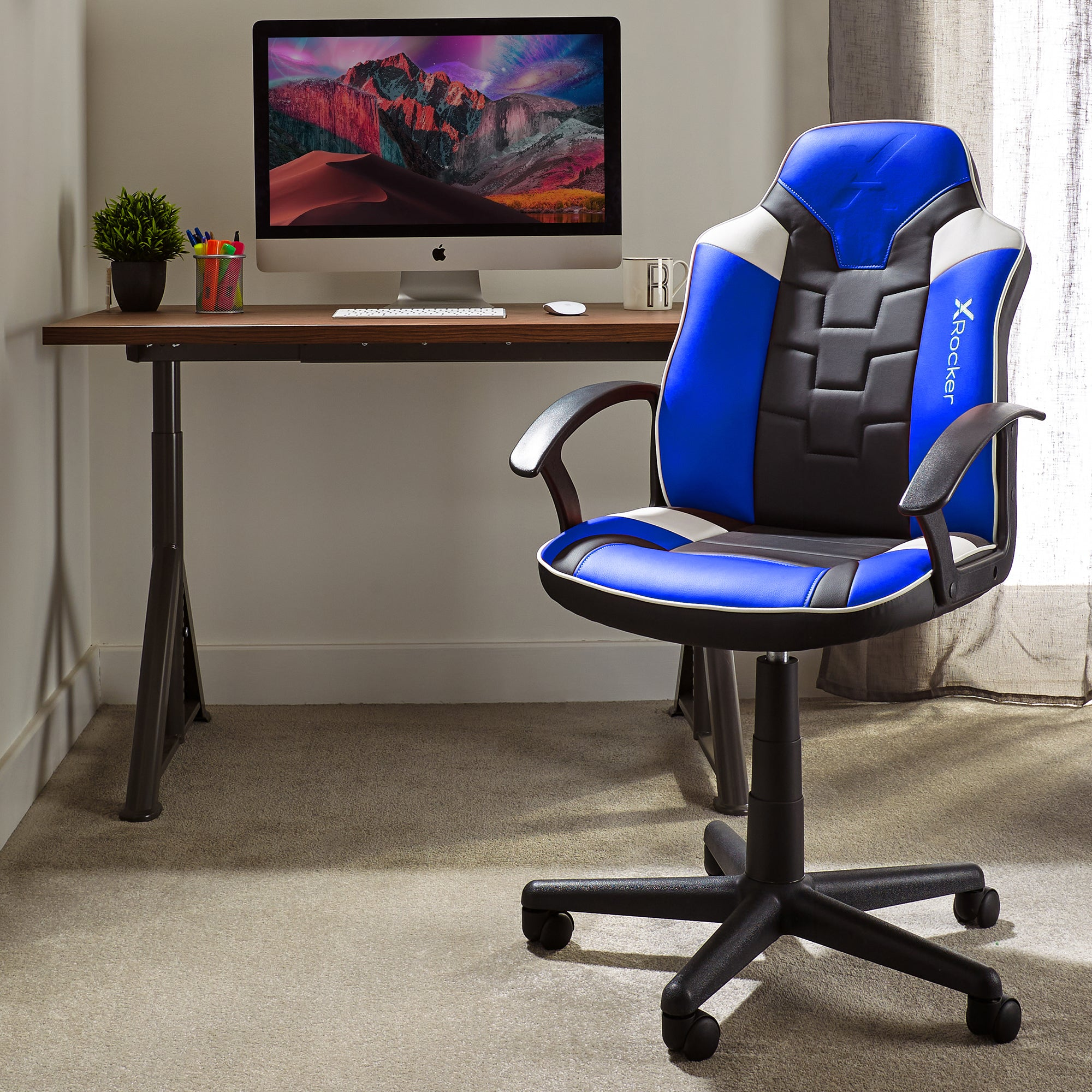 Ein Gaming-Stuhl in einem Raum mit Computer-Setup auf einem Schreibtisch.