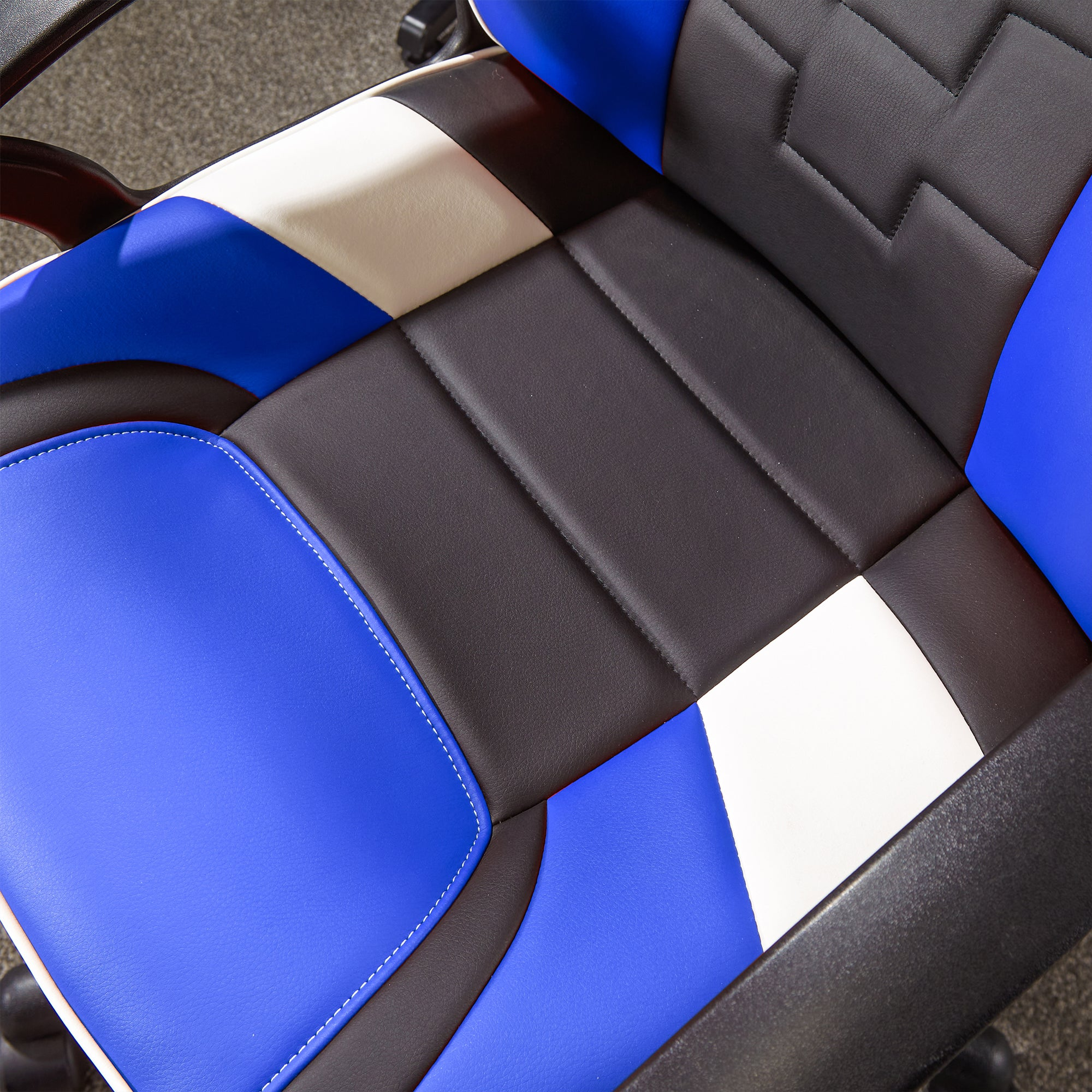 Nahaufnahme eines blau-schwarz-weißen Gaming-Stuhlsitzes. Der Sitz hat ein gestepptes Design.