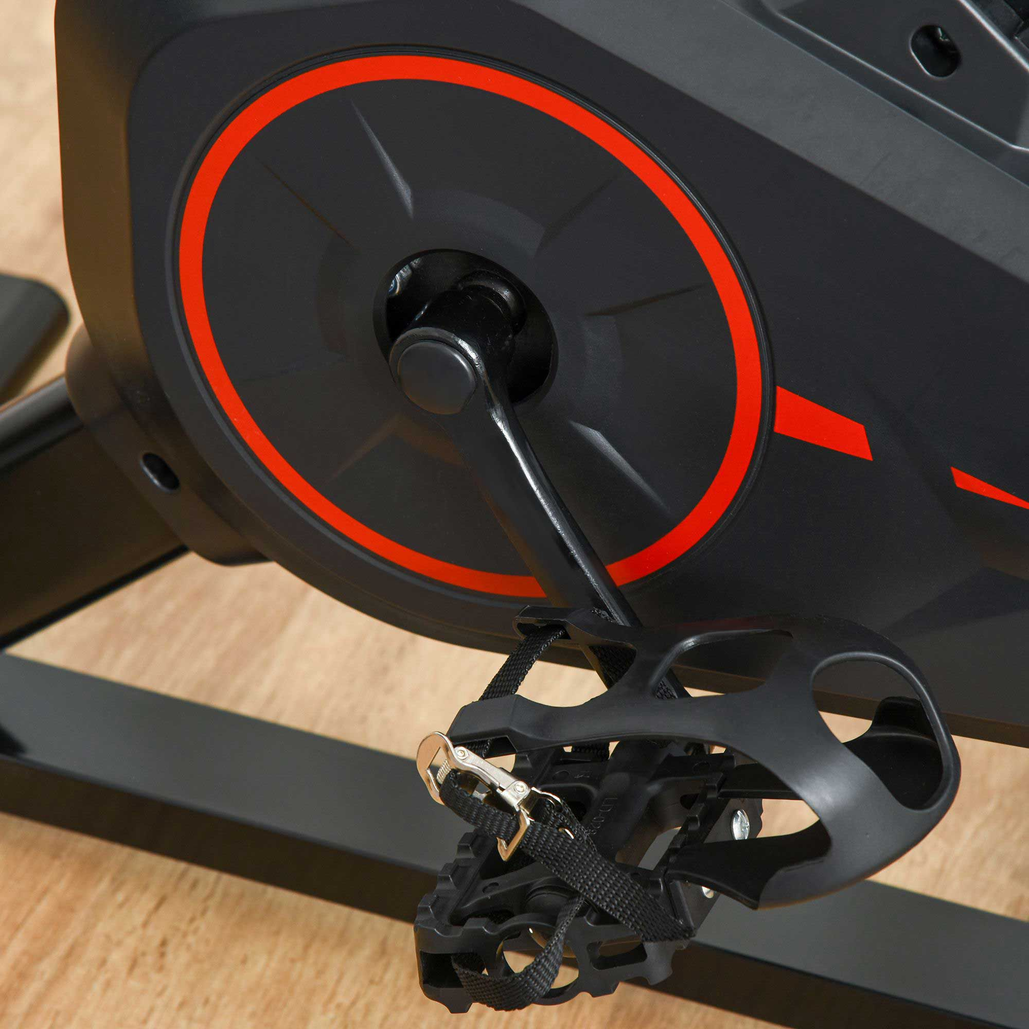 Nahaufnahme eines Heimtrainerpedals. Das Pedal ist schwarz mit rotem Kreis und Riemen.