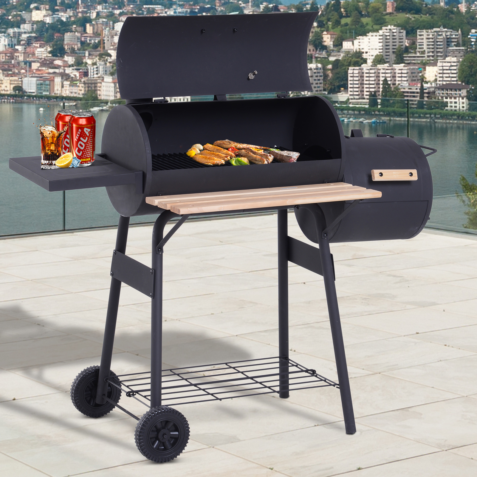 Una parrilla negra en un patio, con latas de cola y una vista de un lago y edificios.
