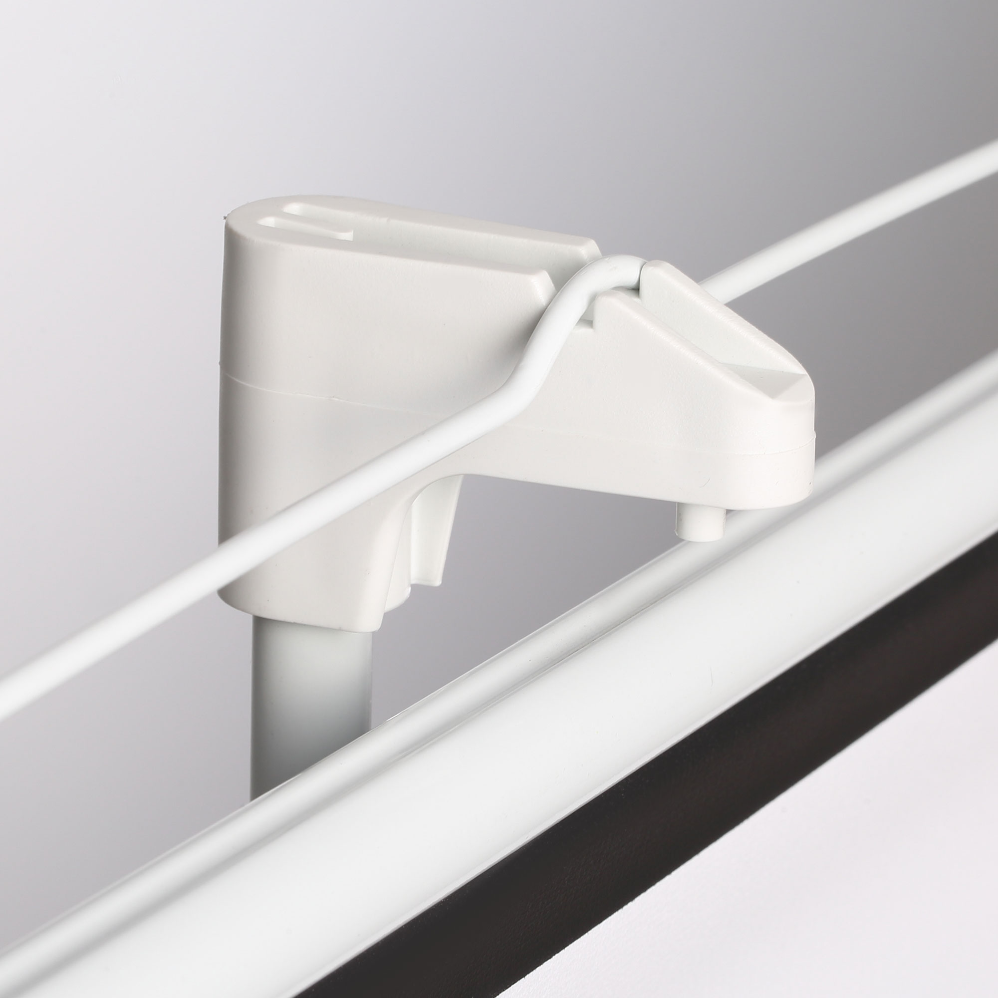 Primer plano de una estructura blanca en forma de gancho que sostiene un cable blanco.