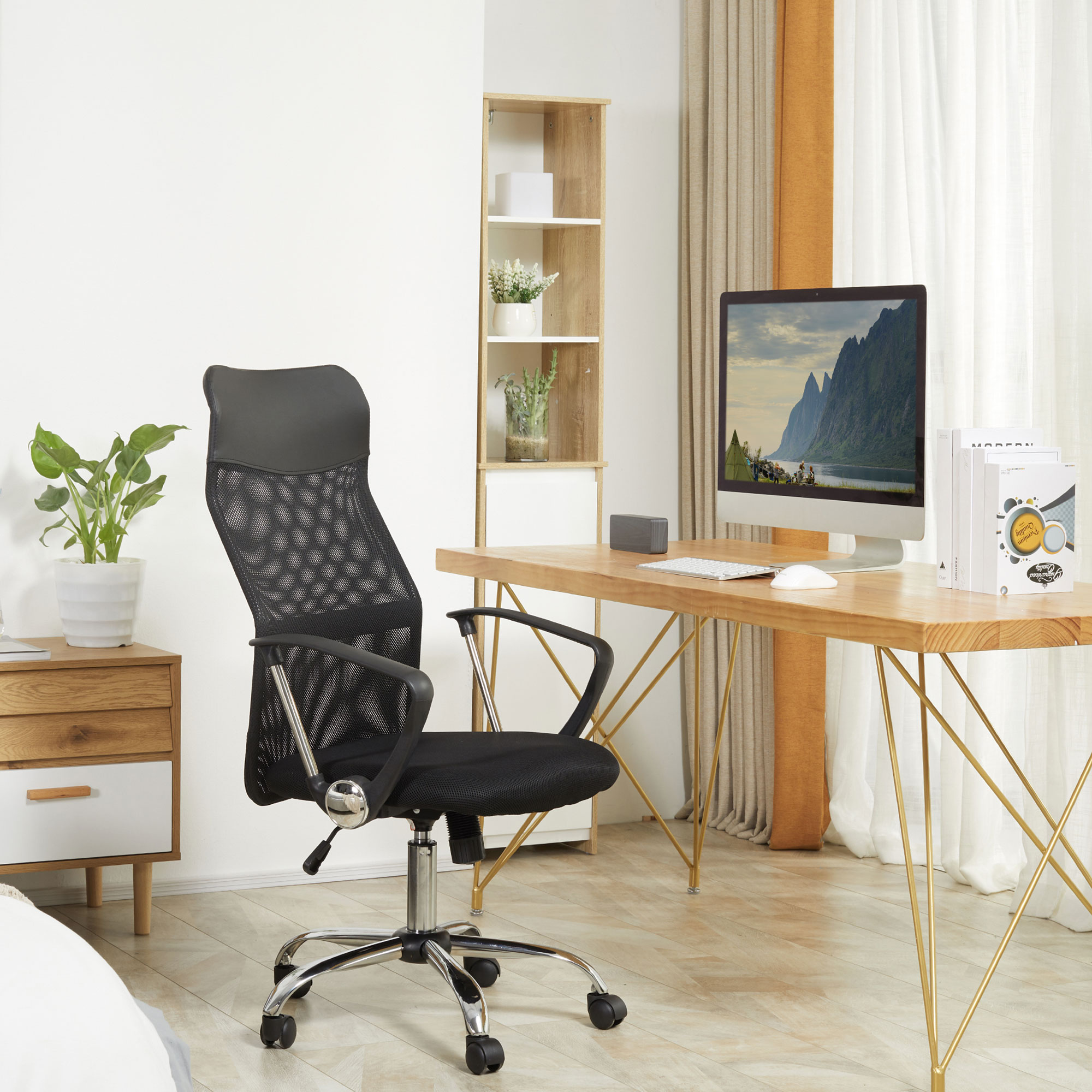 Silla de oficina de malla negra en un entorno de oficina en casa con escritorio, computadora y plantas.