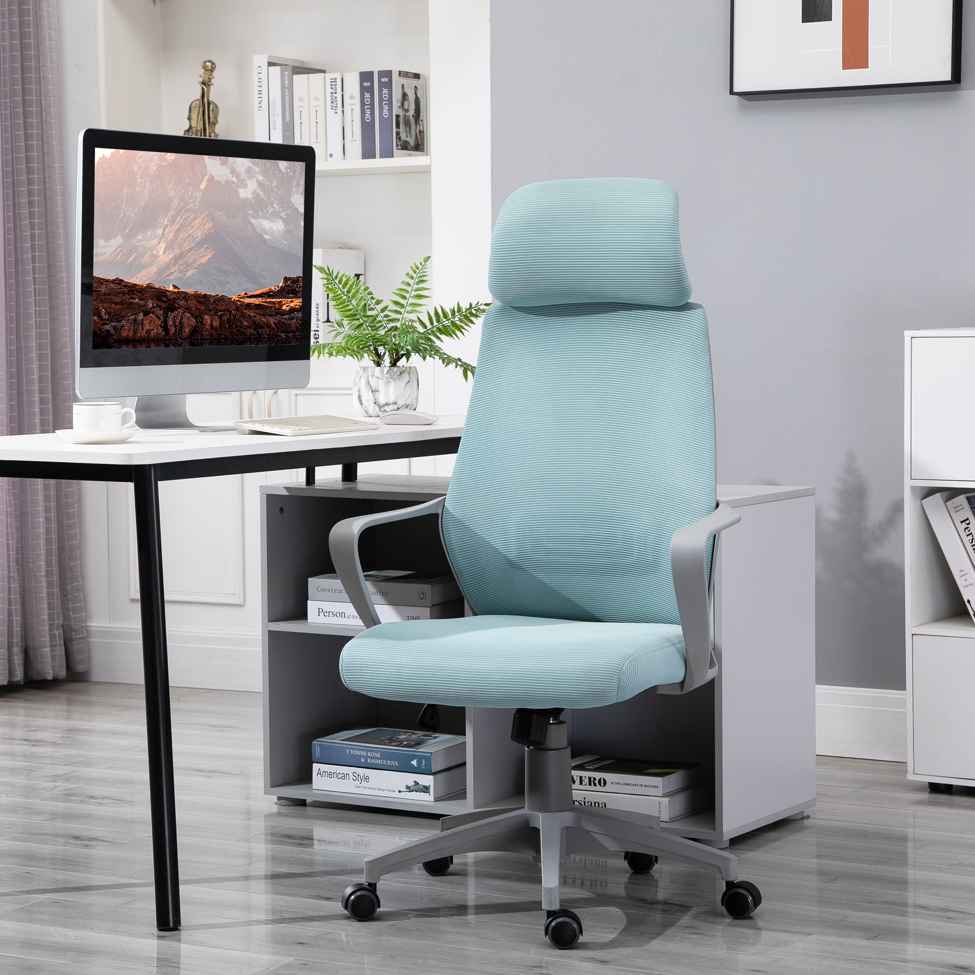 Configuración de oficina: silla azul, escritorio con ordenador y estantería.