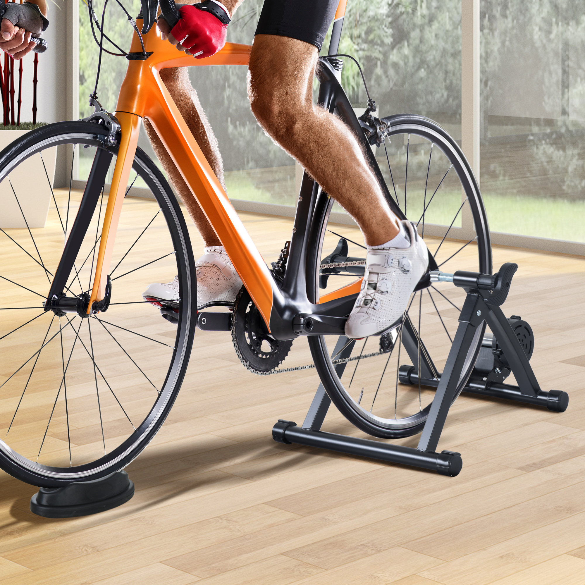 Hombre en bicicleta estática en un entorno doméstico. Muestra las piernas y la configuración de la bicicleta.