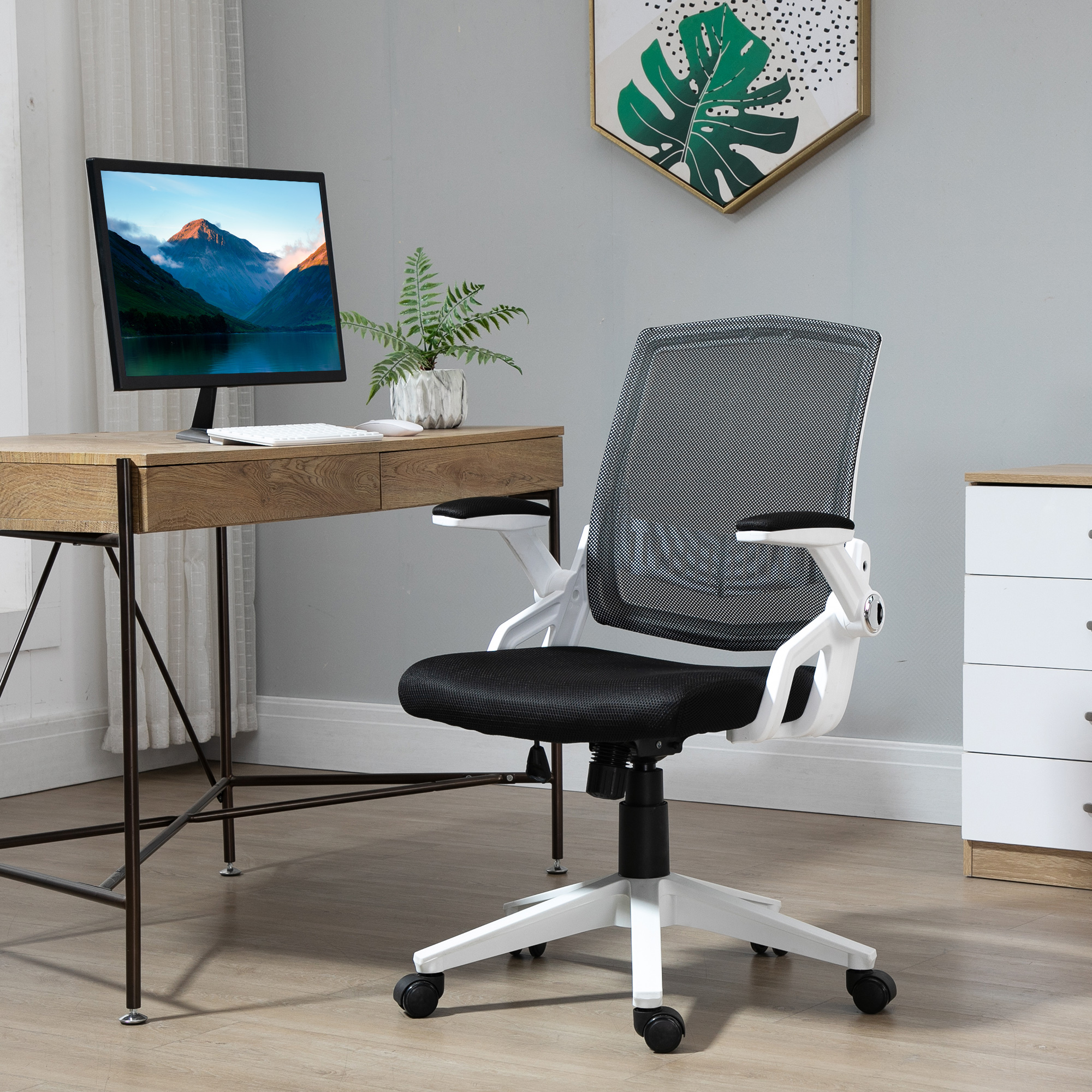 Oficina moderna con una silla de respaldo de malla gris, un escritorio de madera con un monitor y un armario blanco.
