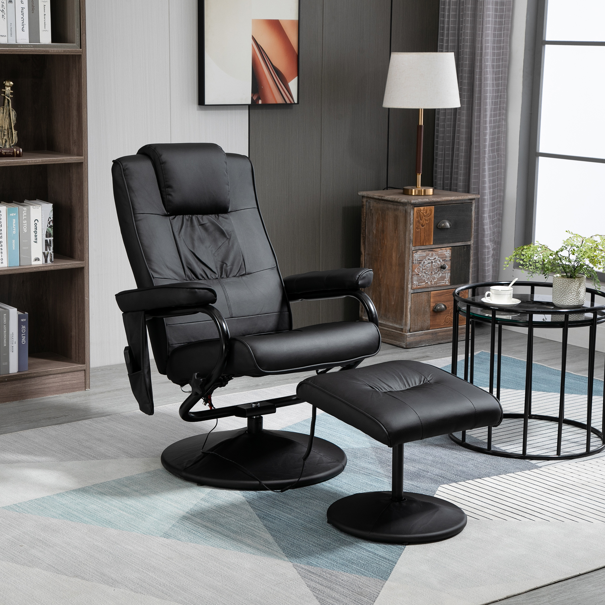 Sillón reclinable de cuero negro con reposapiés. Estantería, mesa auxiliar y lámpara en el fondo.