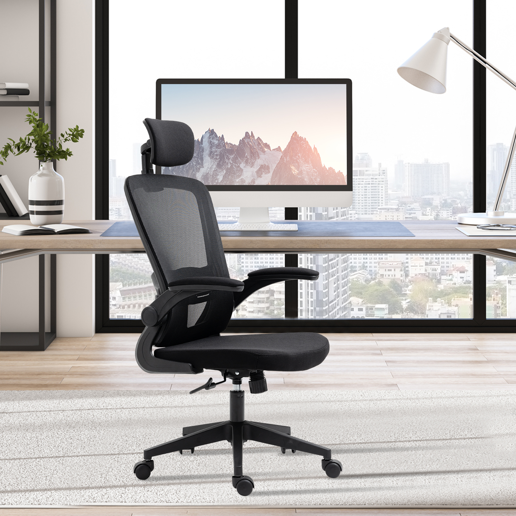 Silla de oficina negra en un entorno de oficina. Ventana, escritorio y computadora son visibles.