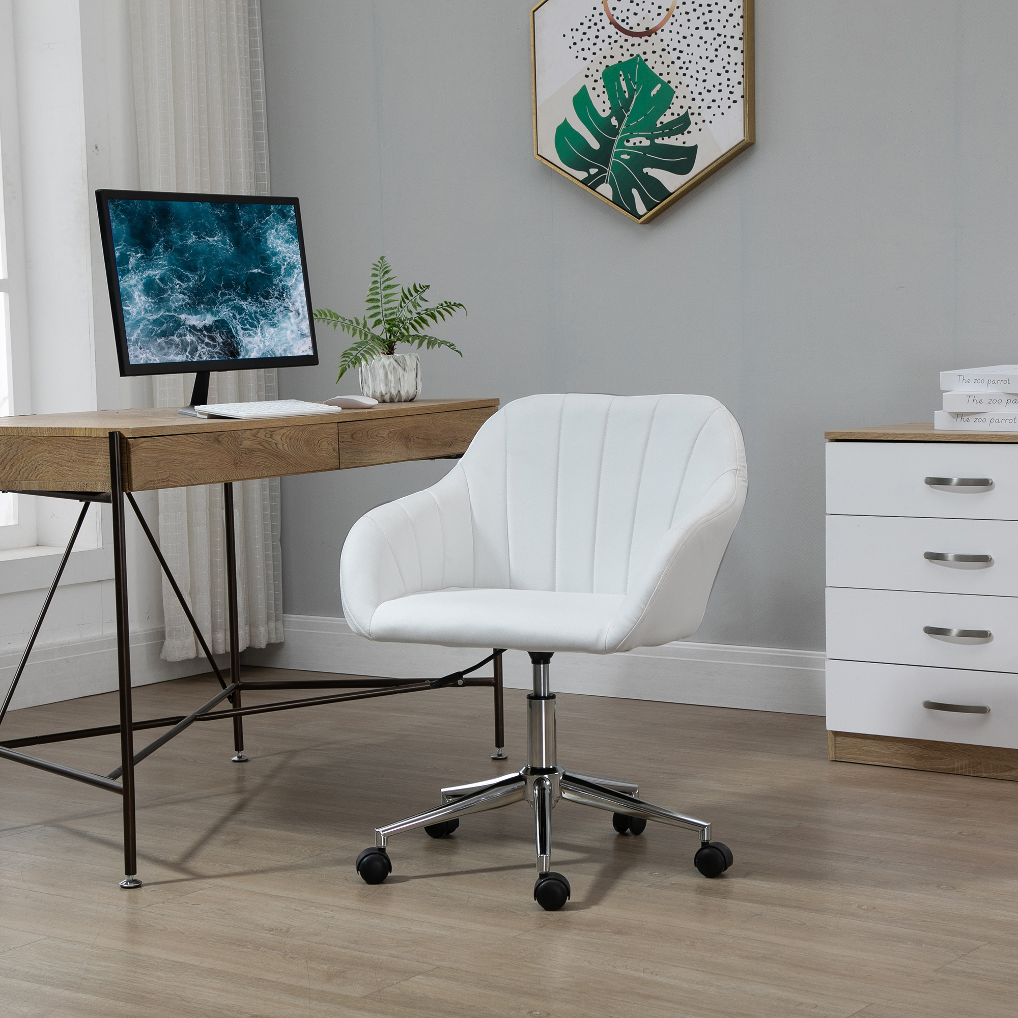 Silla de oficina blanca con escritorio de madera. Un monitor de computadora y una planta están sobre el escritorio.