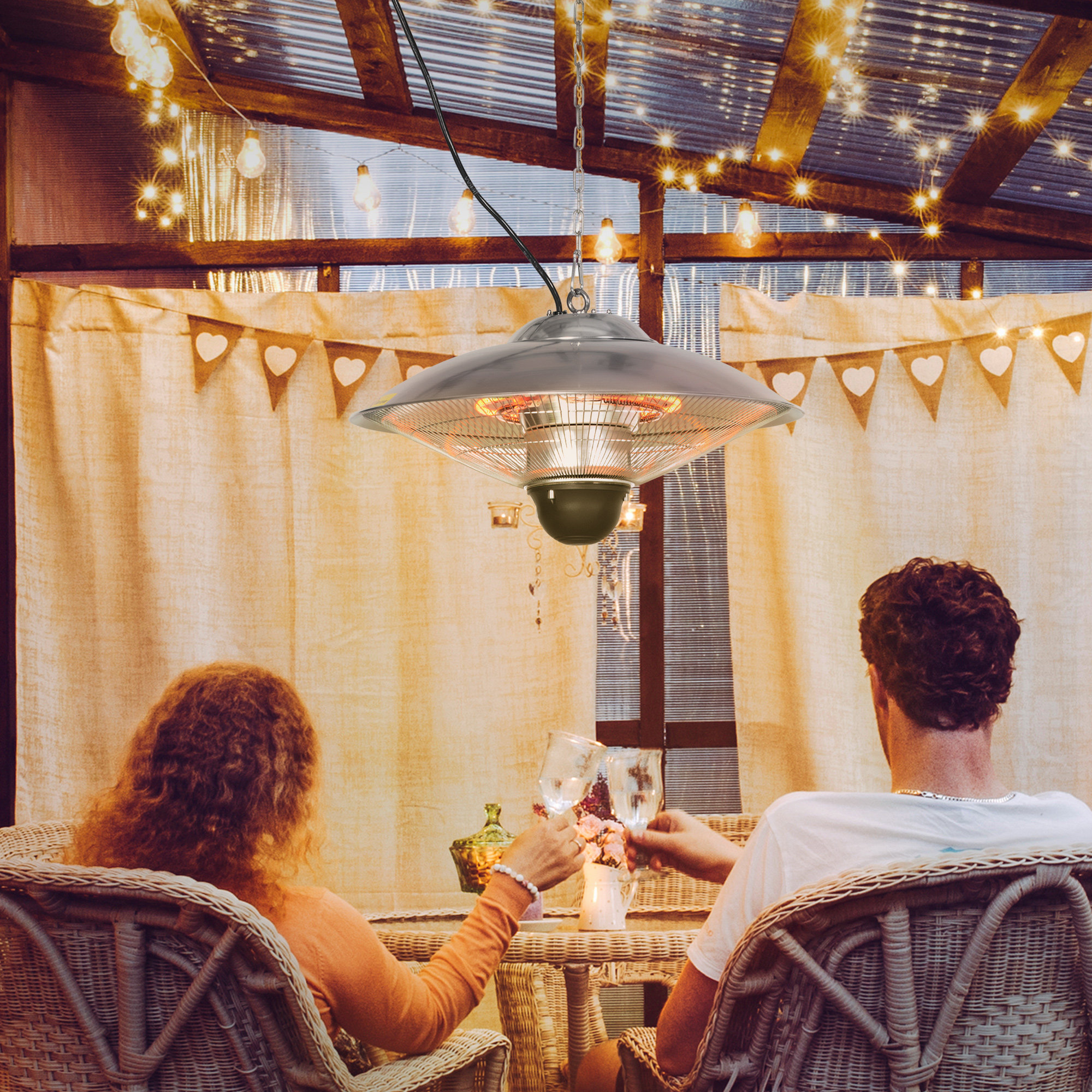Una pareja brindando con vino debajo de un calefactor de patio.