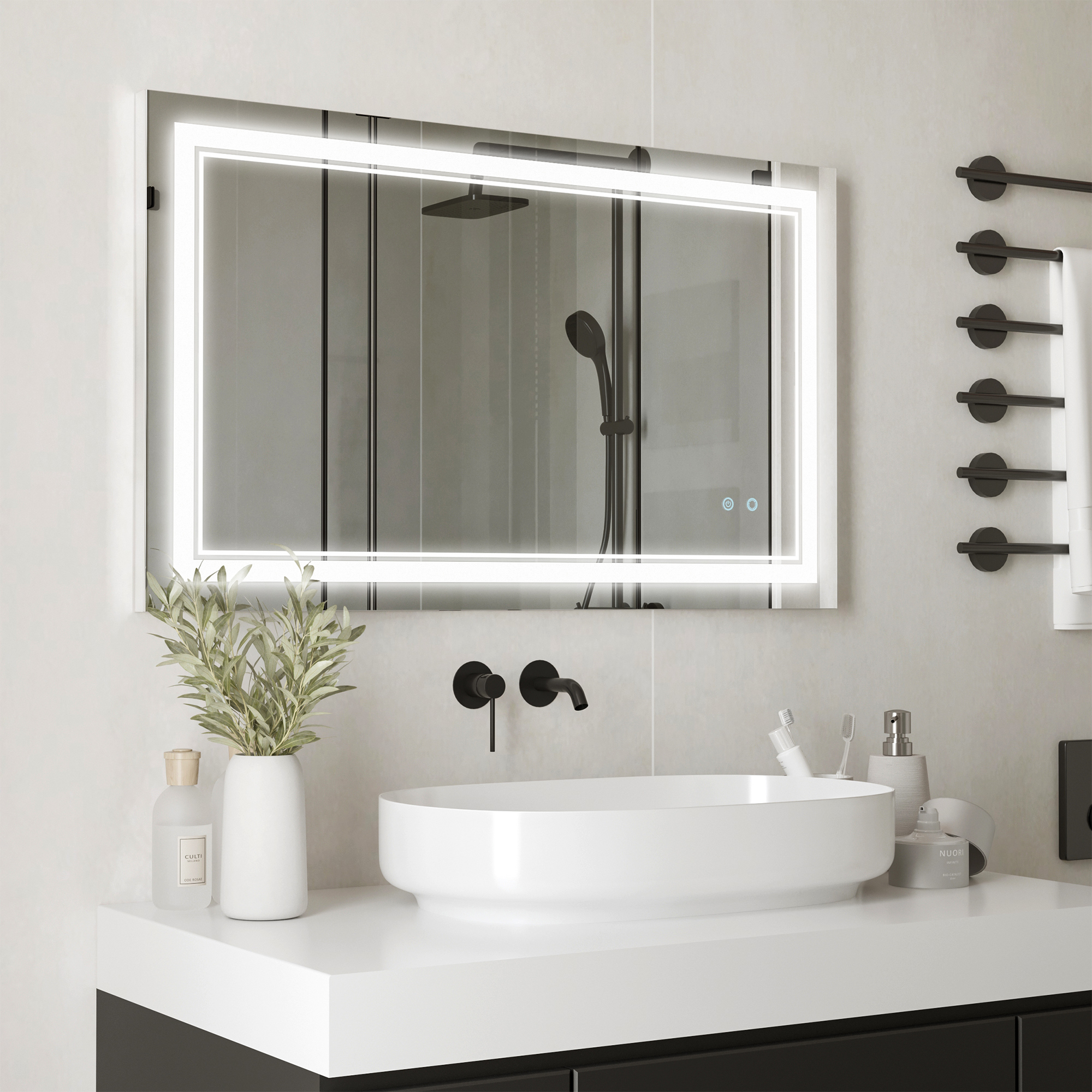 Baño moderno con espejo iluminado sobre lavabo blanco. Accesorios y plantas visibles.