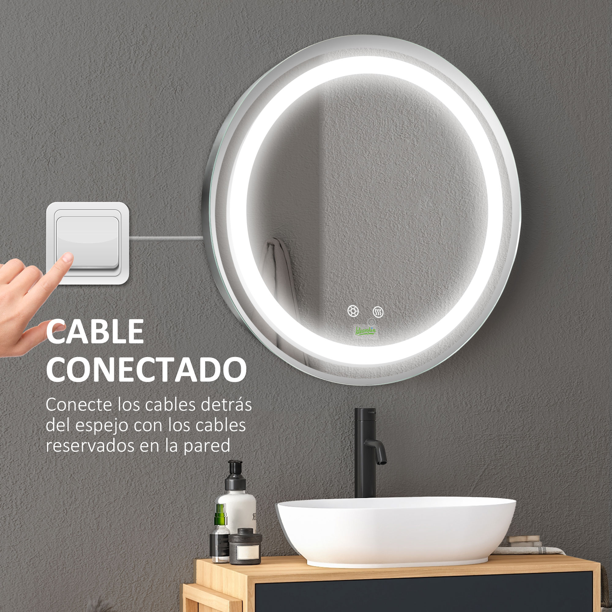 Espejo redondo iluminado en el baño. Una mano presiona un interruptor de luz. Lavabo y botellas a la vista.