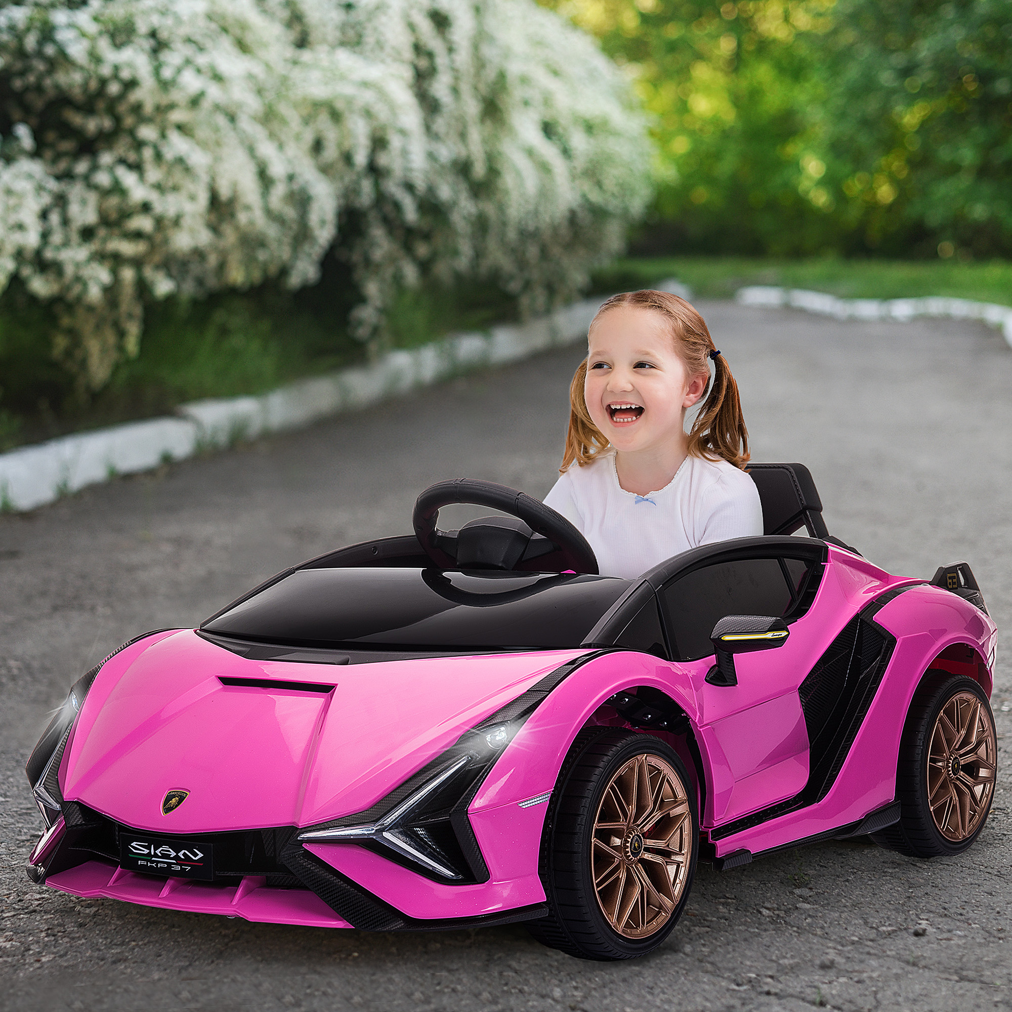 Una niña conduce un coche de juguete rosa en una carretera pavimentada, sonriendo con alegría.