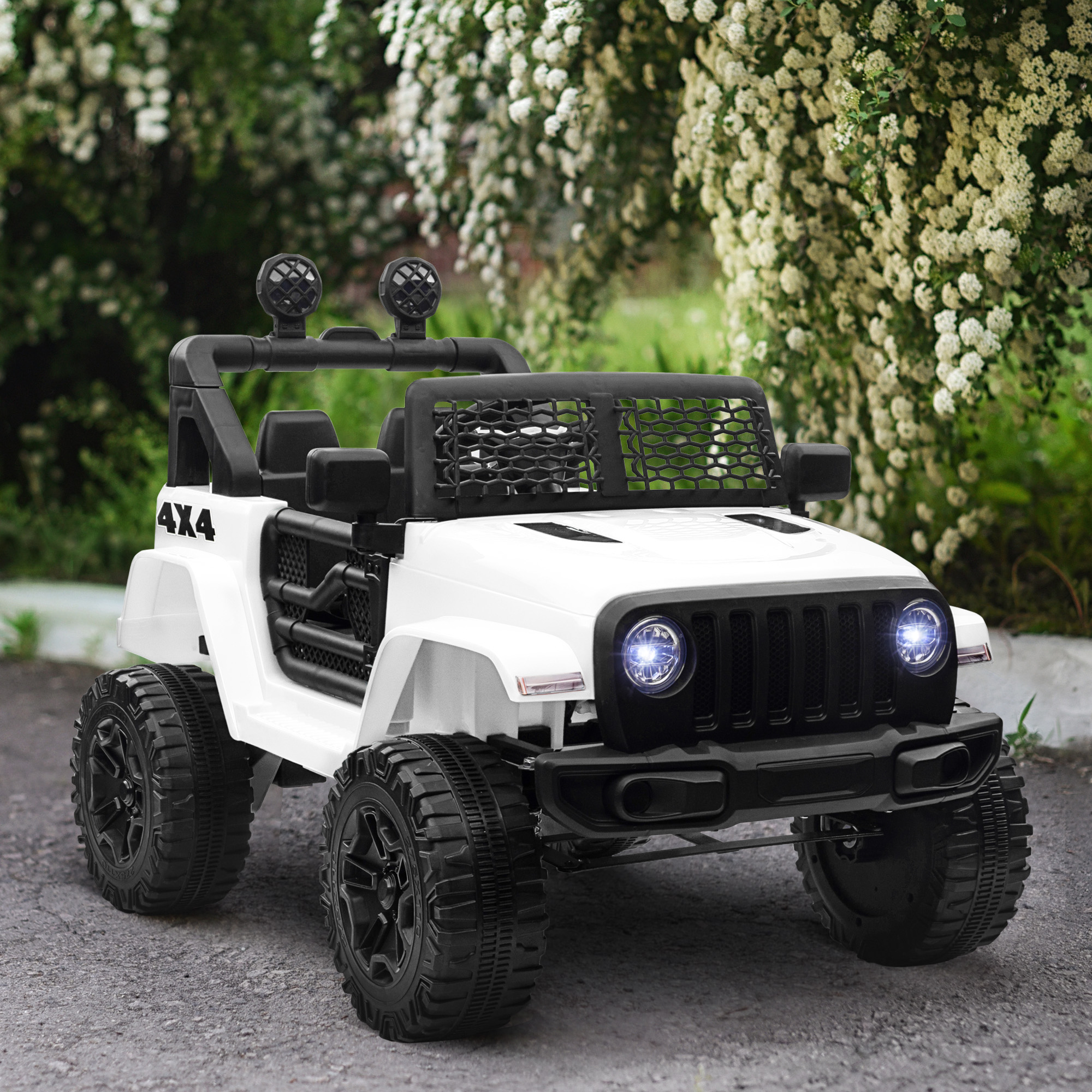 Jeep giocattolo bianco, dettagli neri, 4x4. Parcheggiato su un sentiero, vegetazione lussureggiante sullo sfondo, giornata di sole.