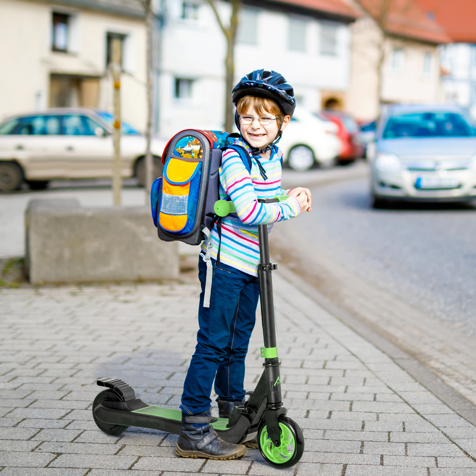 Ragazzo con zaino e casco su un monopattino elettrico su una strada di mattoni. Sfondo: auto ed edifici.