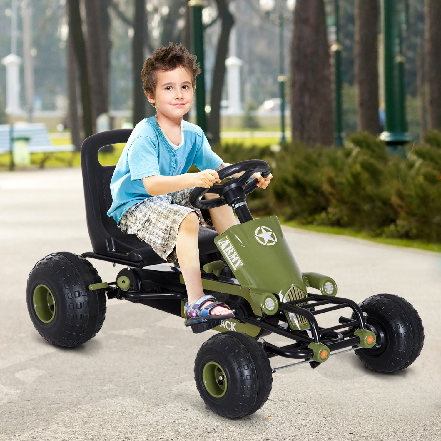Niño conduciendo un kart de pedales verde. Cuenta con volante y asiento negro, en un camino pavimentado.