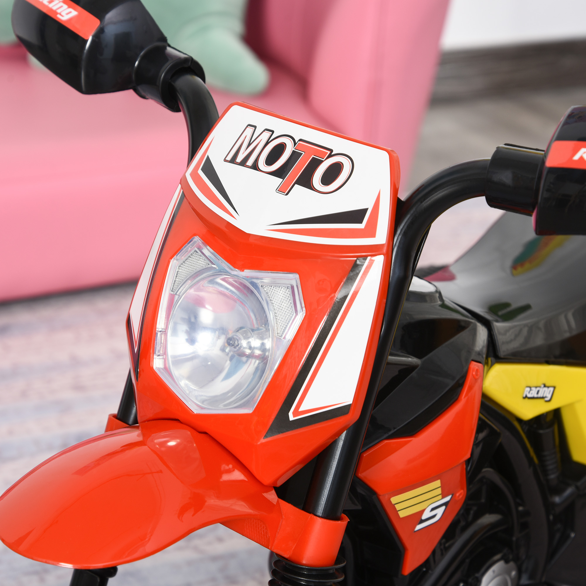 Primer plano de una moto de juguete roja y negra. Incluye faro y detalles del manillar.