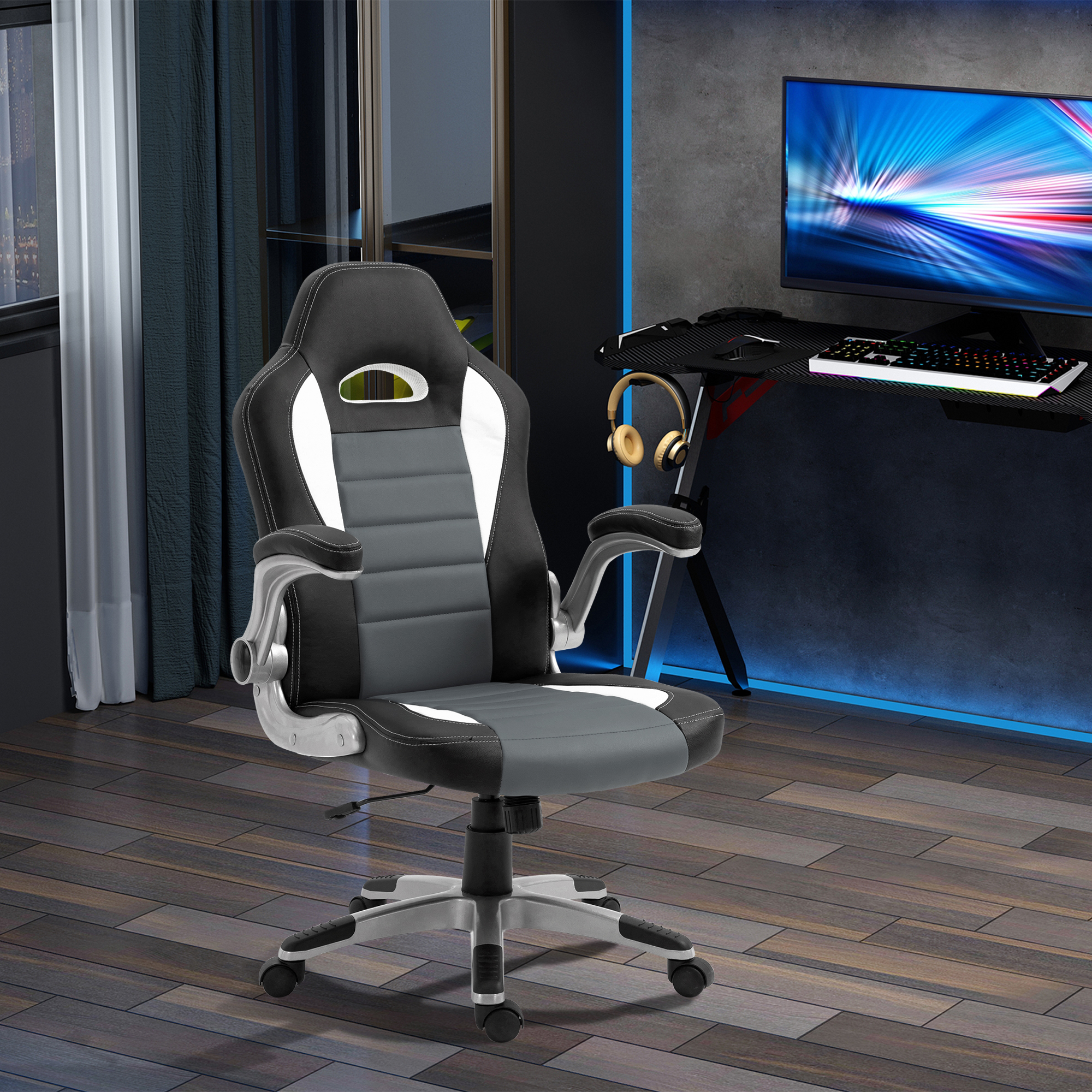 Silla gaming: negra, gris y blanca con base plateada en una habitación con escritorio y ordenador.