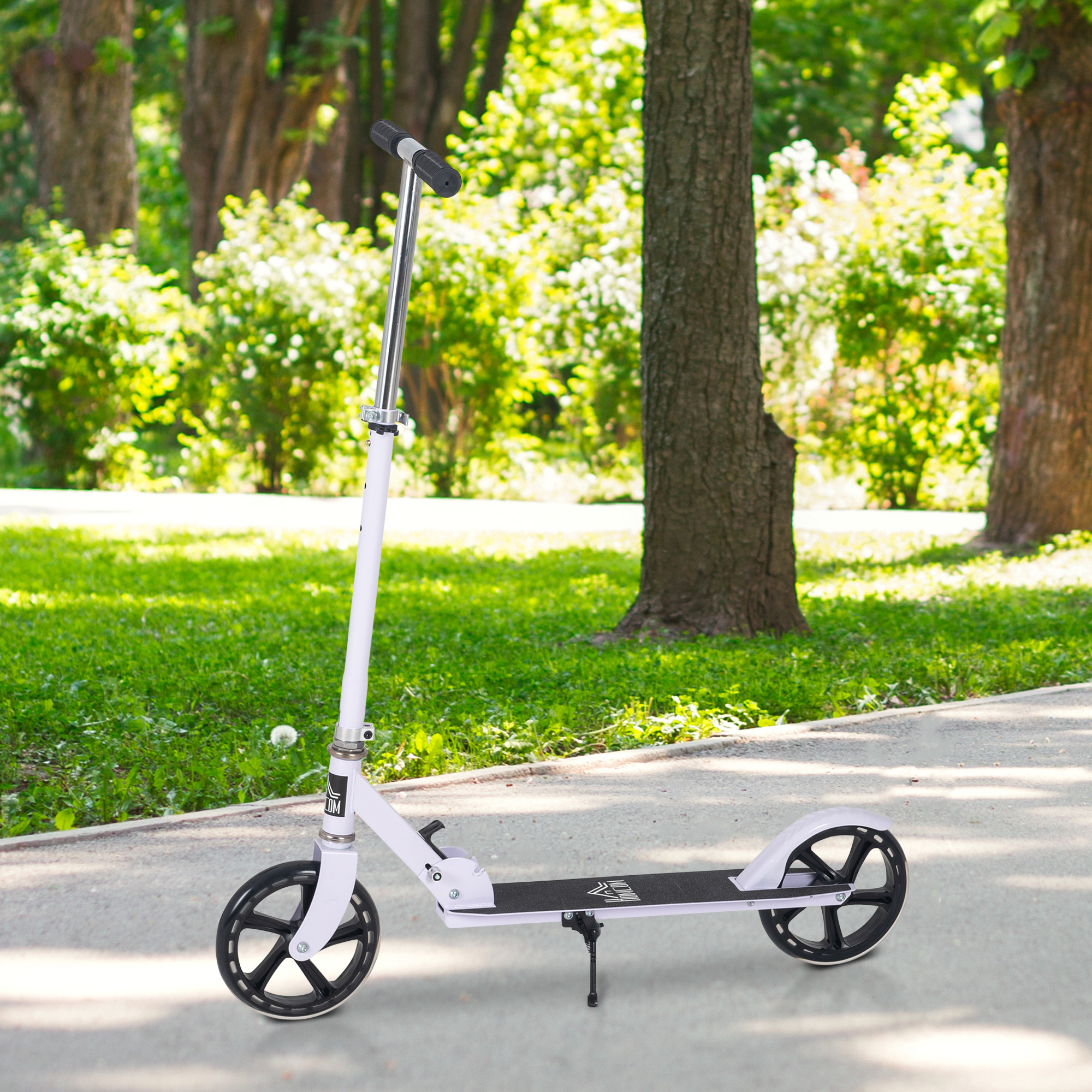Patinete plegable blanco en una acera. El fondo es un parque con árboles y césped. Día soleado.