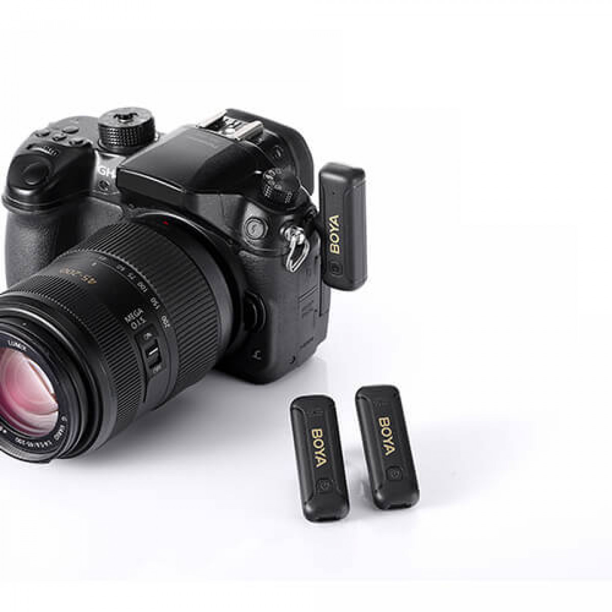 Fotocamera con due microfoni BOYA. La fotocamera è nera con un obiettivo. I microfoni sono piccoli e neri.