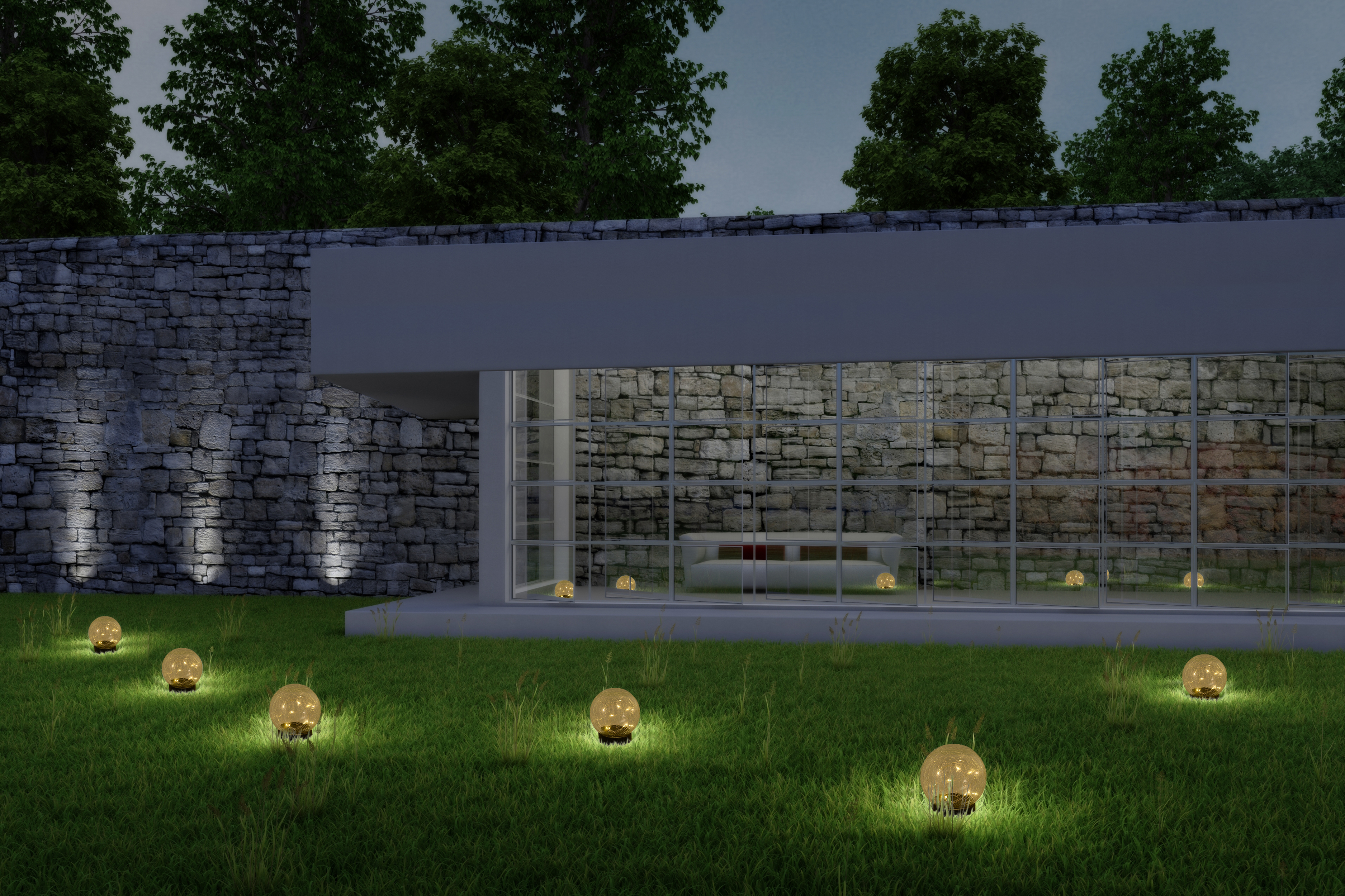 Ein modernes Haus bei Nacht, mit Lichtern im Garten. Das Haus hat eine Steinmauer und Glasfenster.