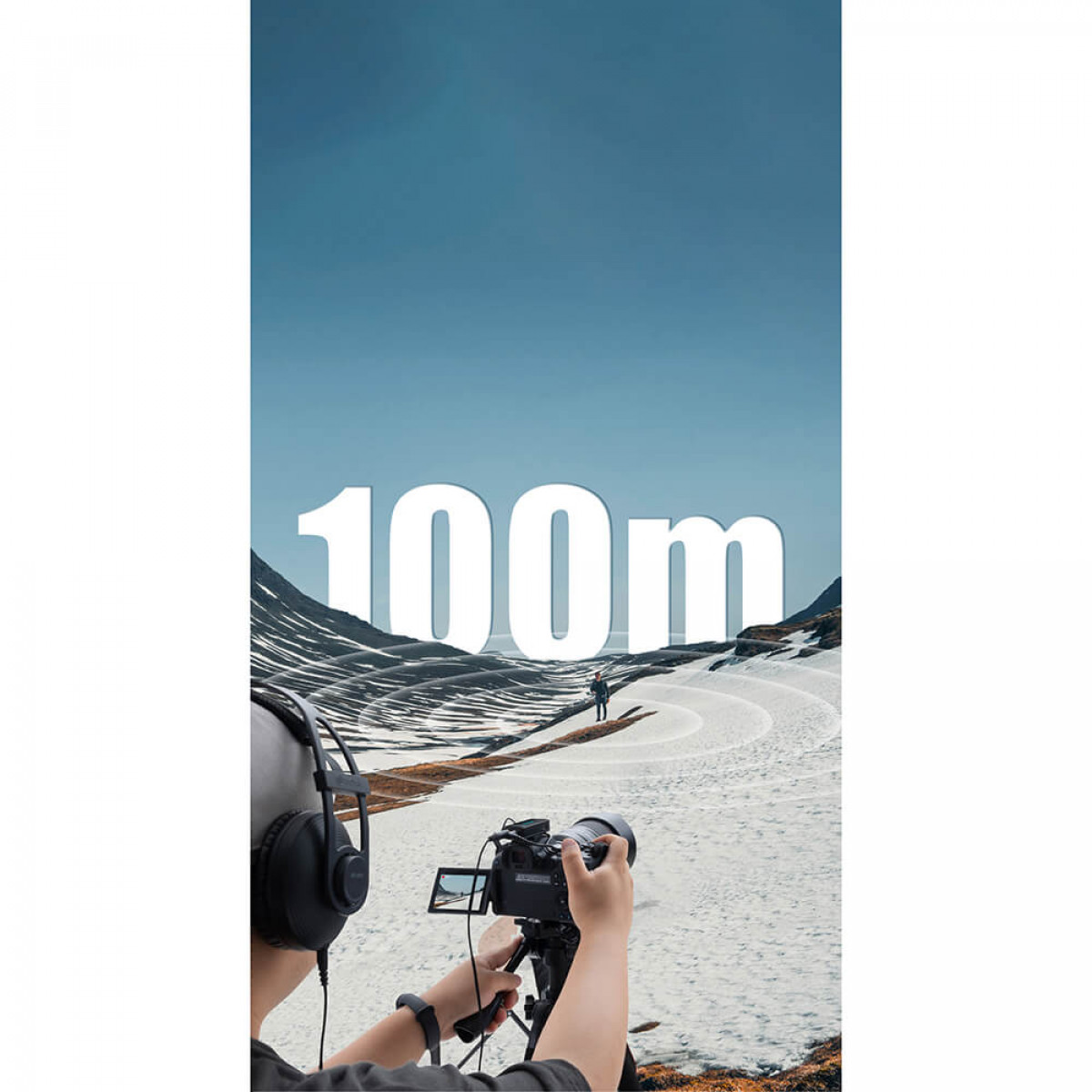 Eine Person filmt schneebedeckte Berge mit einer Kamera, Text 100m sichtbar.