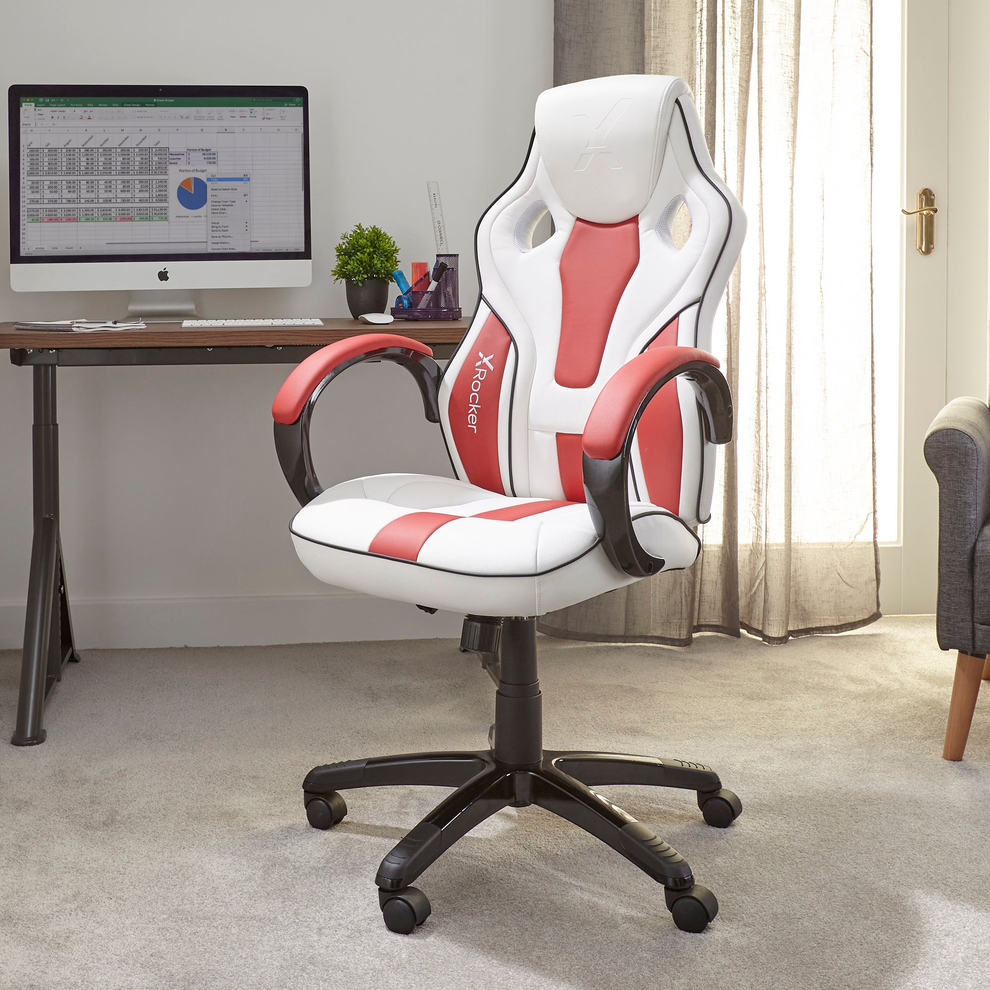 Gaming-Stuhl, weiß und rot, mit Xrocker-Logo. Ein Schreibtisch mit Computer im Hintergrund.