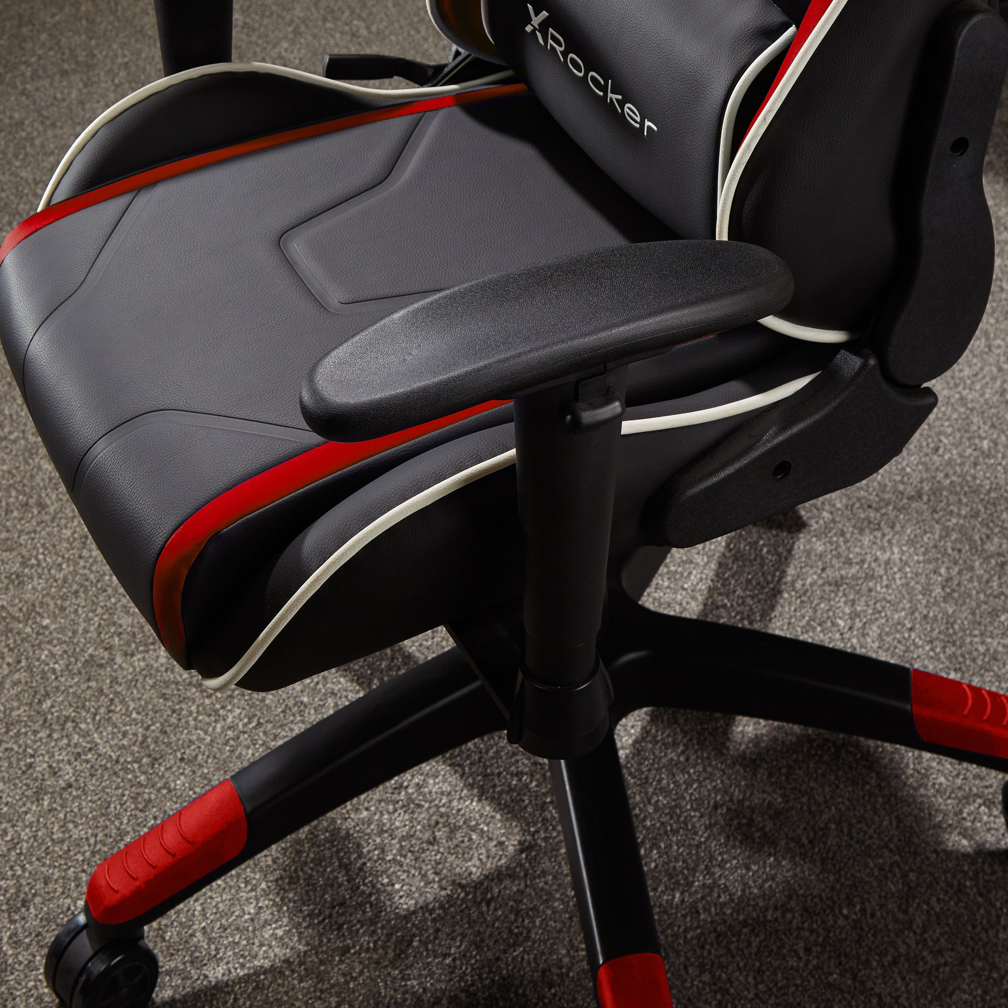 Schwarzer und roter Gaming-Stuhl. Verfügt über einen schwarzen Sitz und Rücken mit roten Akzenten und Kopfstütze.