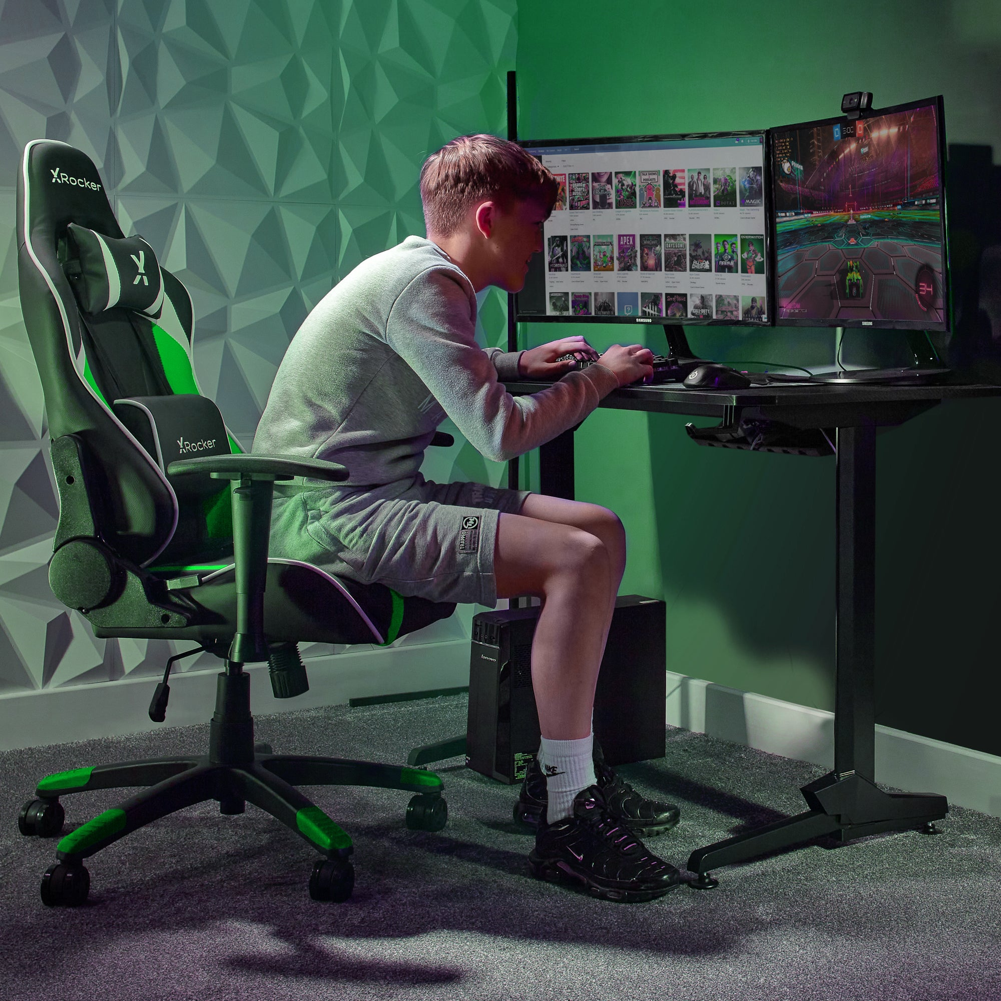 Ein junger Mann spielt ein Spiel an einem Computer mit zwei Monitoren, im Gaming-Stuhl.
