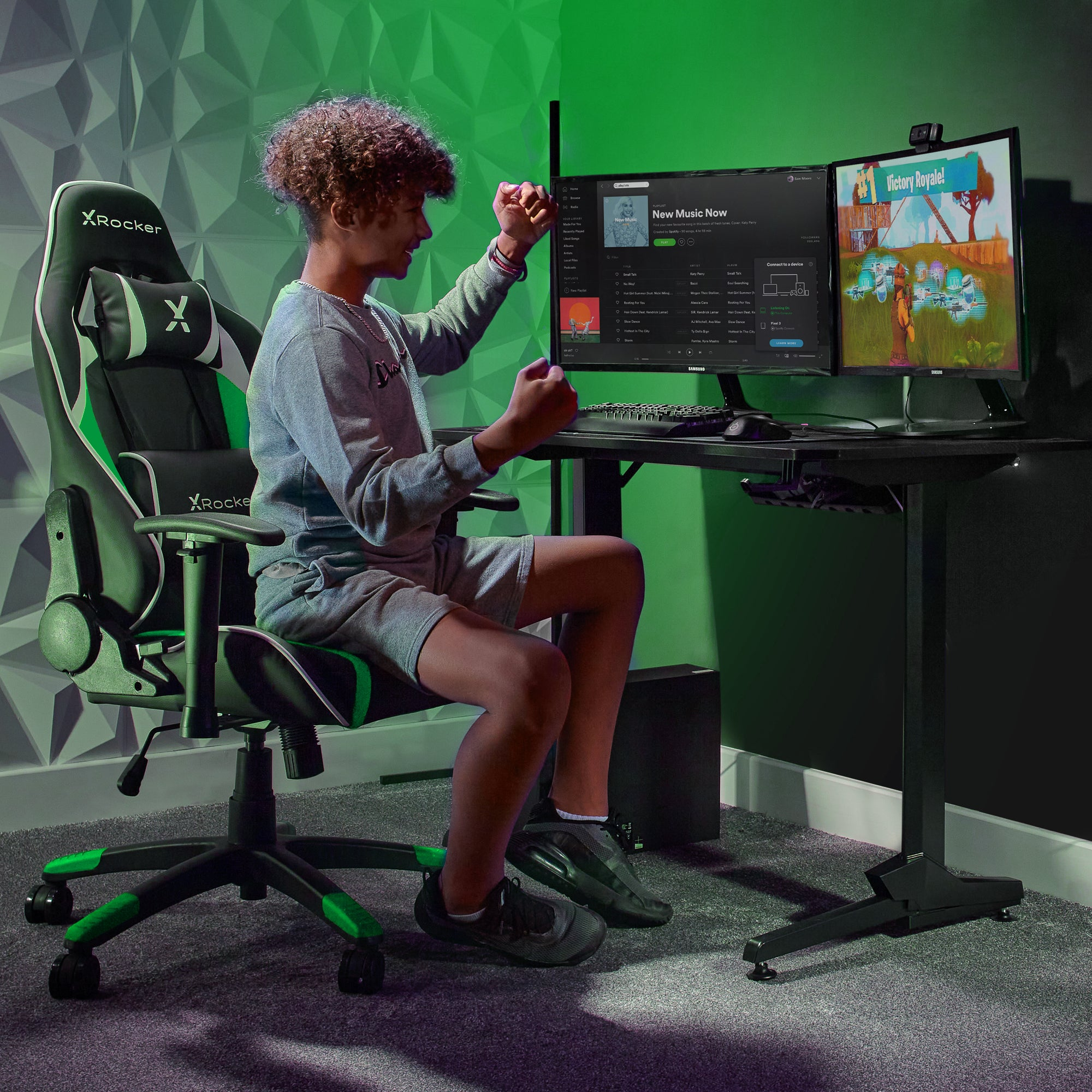 Ein Junge in einem Gaming-Stuhl mit zwei Monitoren, der ein Spiel spielt.