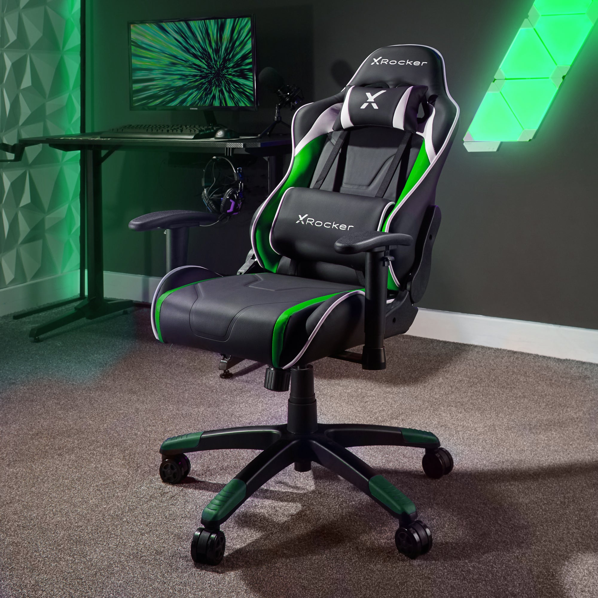 Gaming-Stuhl in einem Raum. Der Stuhl ist schwarz und grün, mit einem Computer und grünen Lichtern im Hintergrund.