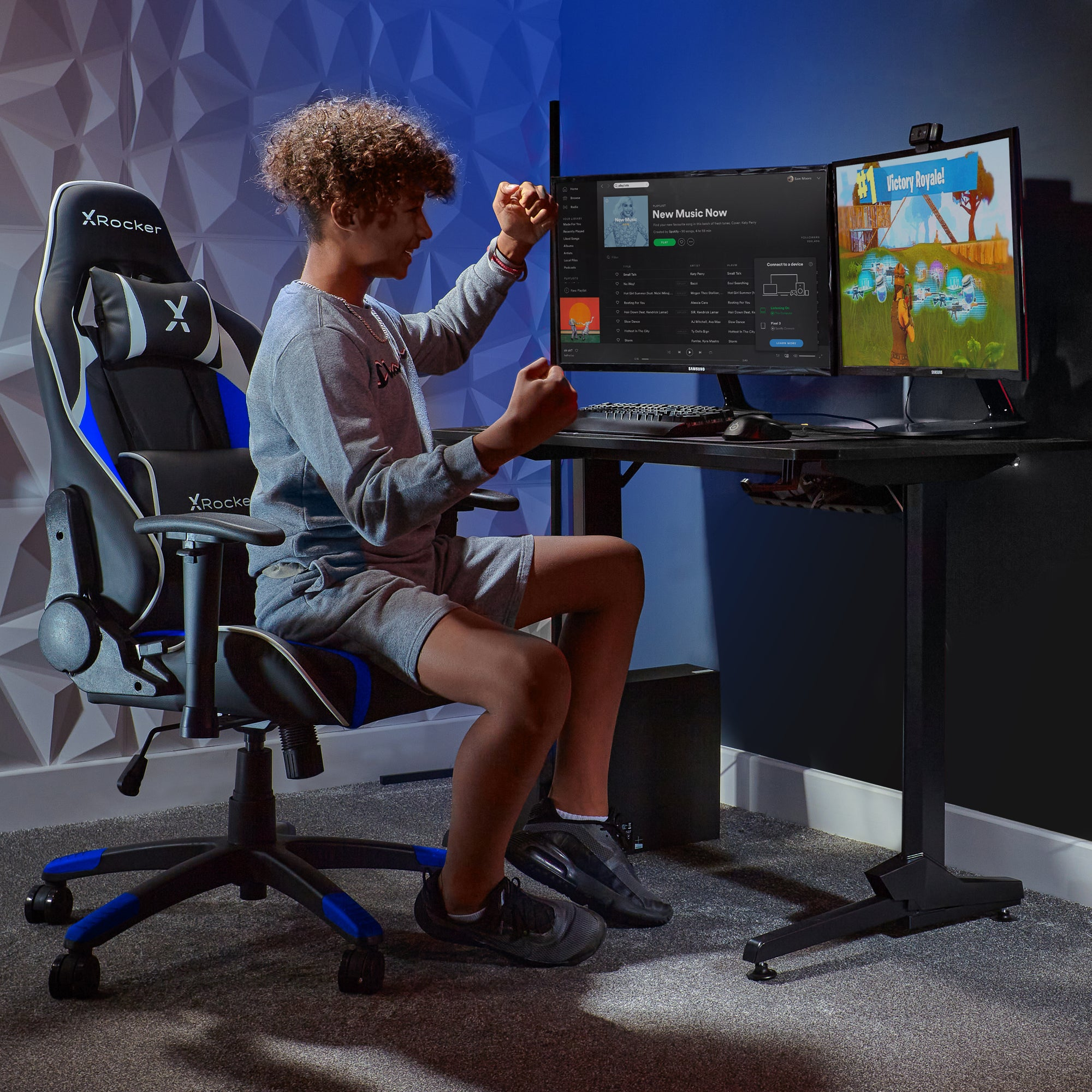 Junger Mann in einem Gaming-Stuhl. Er sitzt vor zwei Computermonitoren. Der Raum ist dunkel.