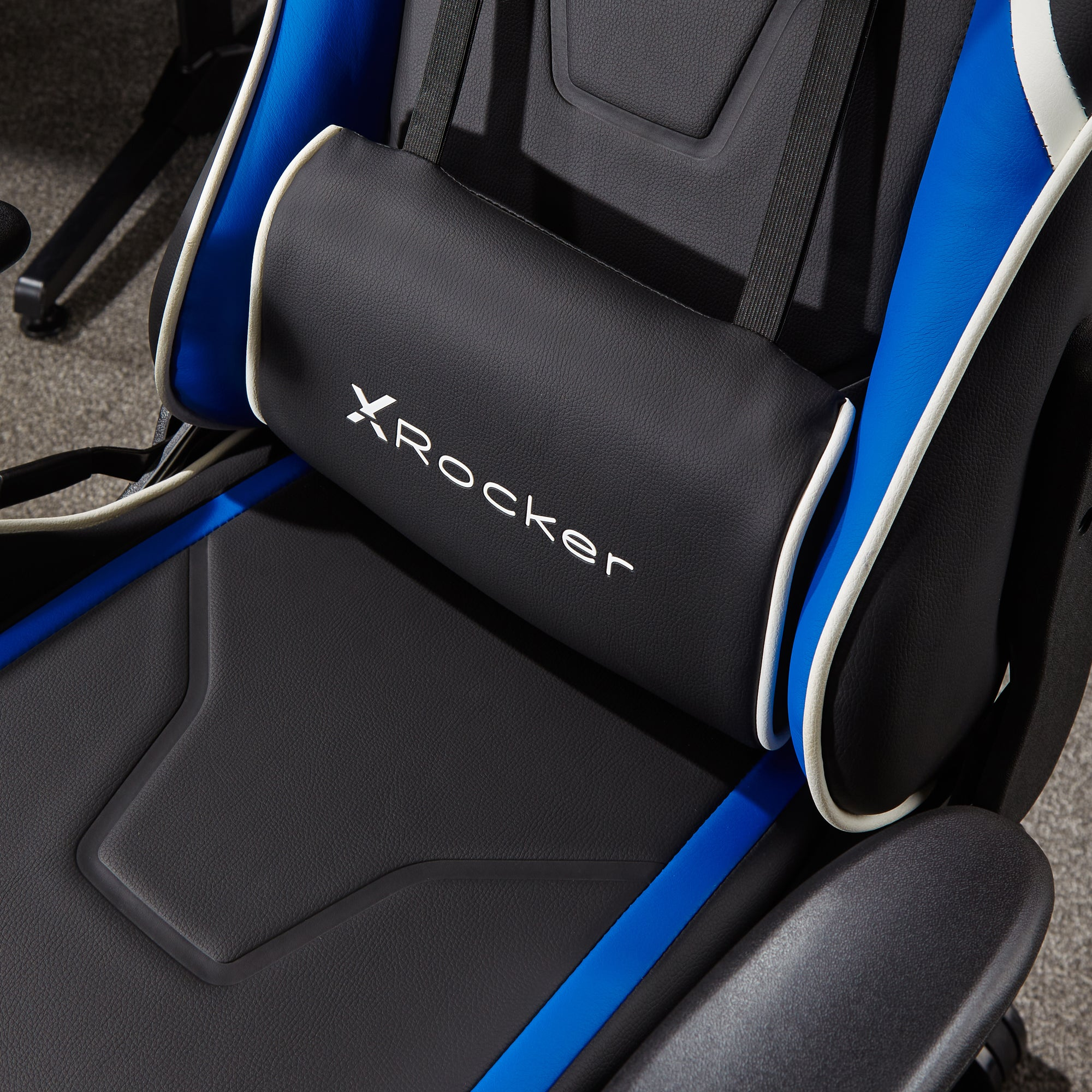 Nahaufnahme der Rückenlehne eines Gaming-Stuhls mit dem Logo "X Rocker" auf schwarzem Kissen.