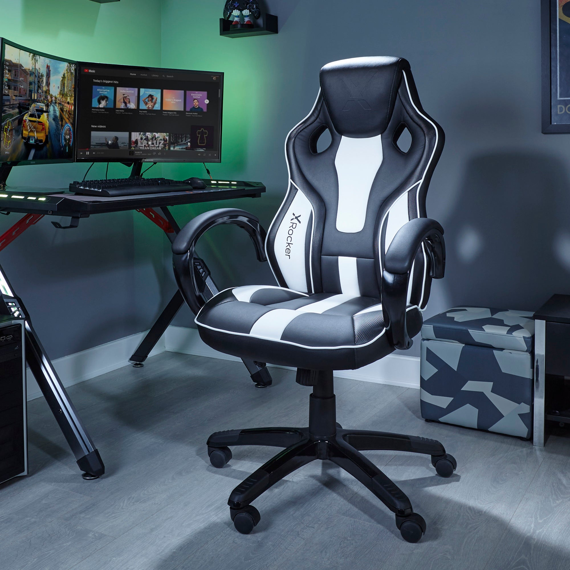 Ein Gaming-Stuhl in einem Raum mit Computer-Setup. Der Stuhl ist schwarz und weiß.