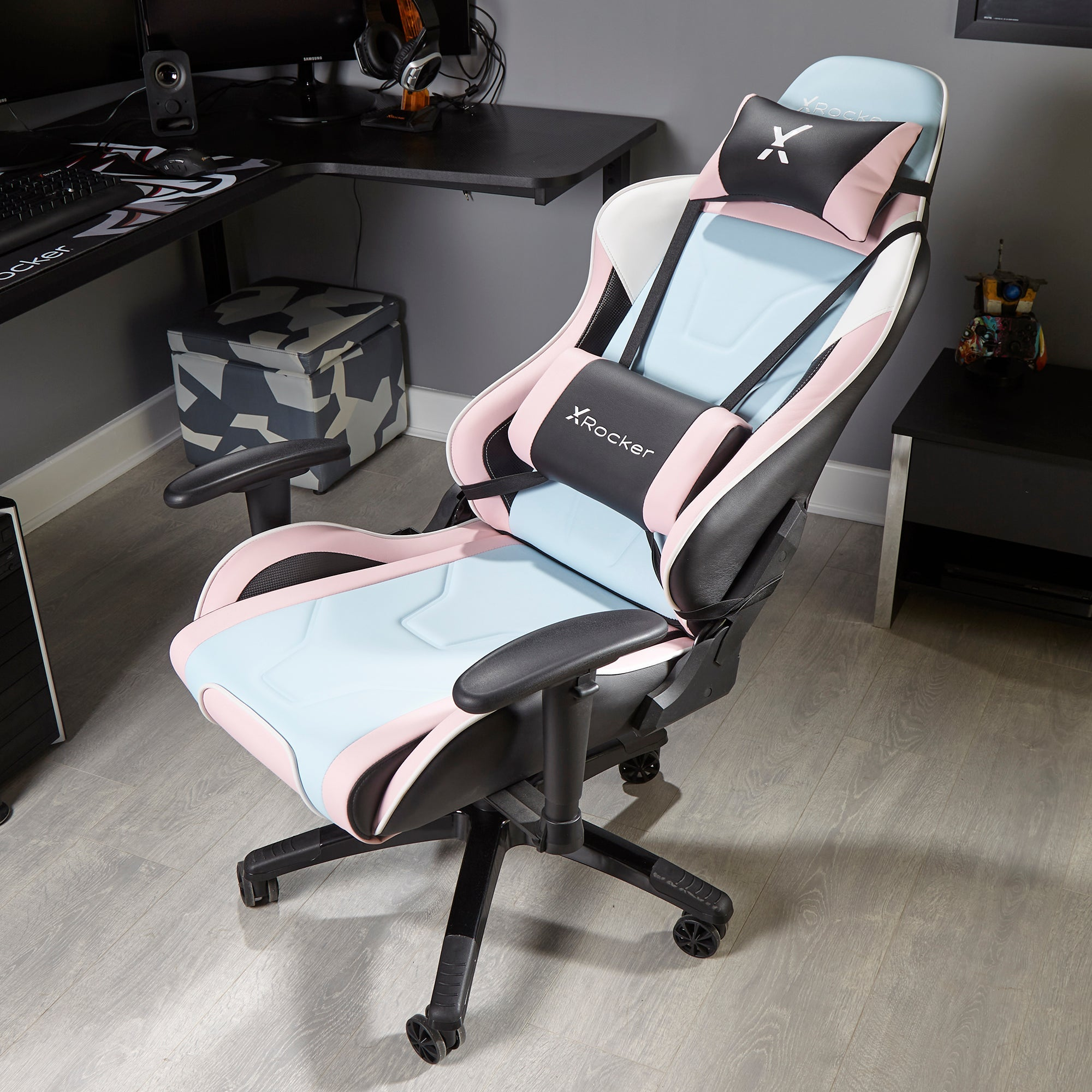 Gaming-Stuhl mit blauen, rosa und schwarzen Akzenten. Der Stuhl steht in einem Raum mit Schreibtisch.