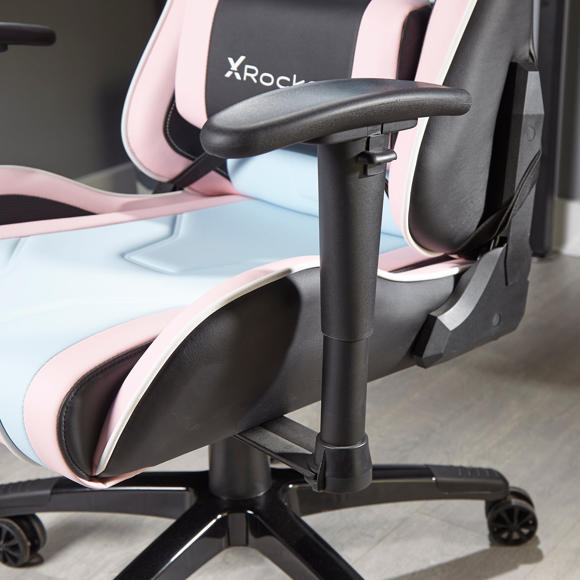 Rosa, schwarzer und blauer Gaming-Stuhl mit schwarzen Armlehnen.