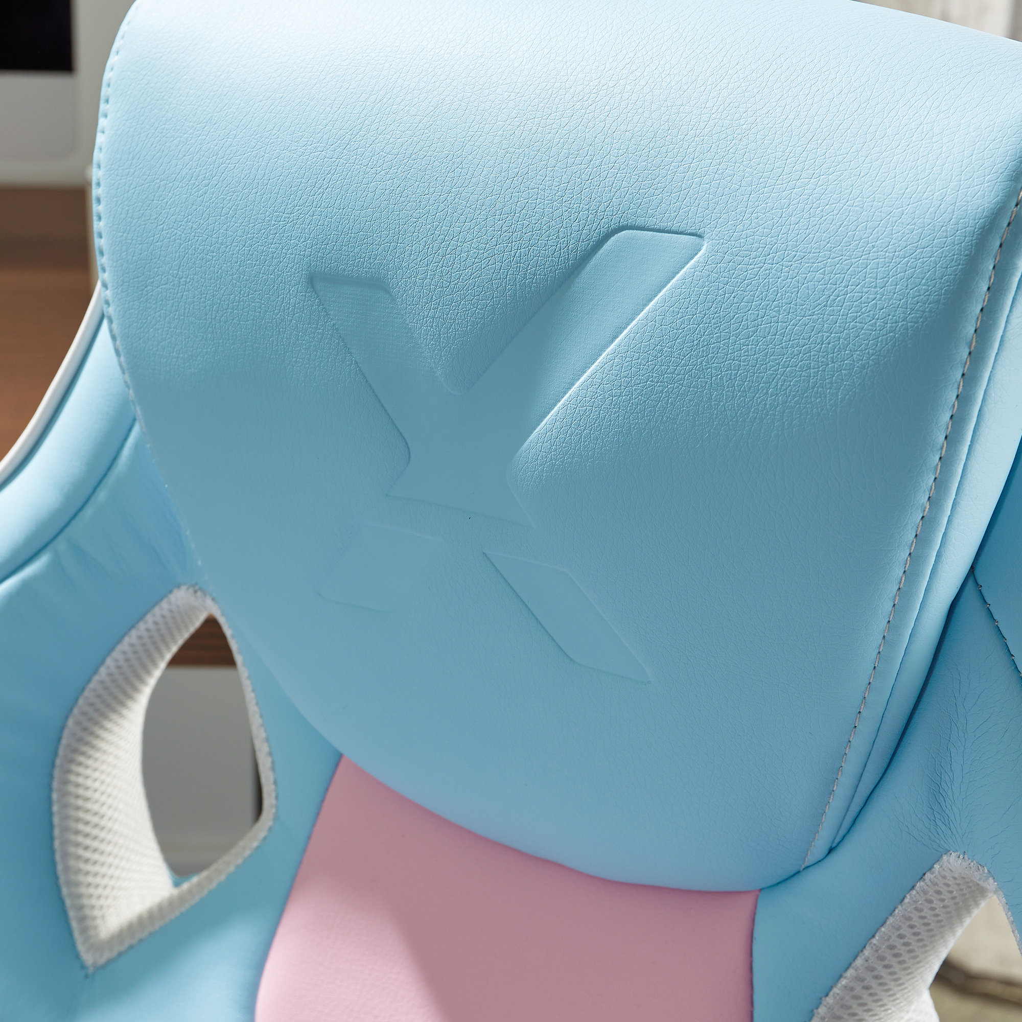 Ein blau-rosa Gaming-Stuhl mit einem X-Logo auf der Kopfstütze.