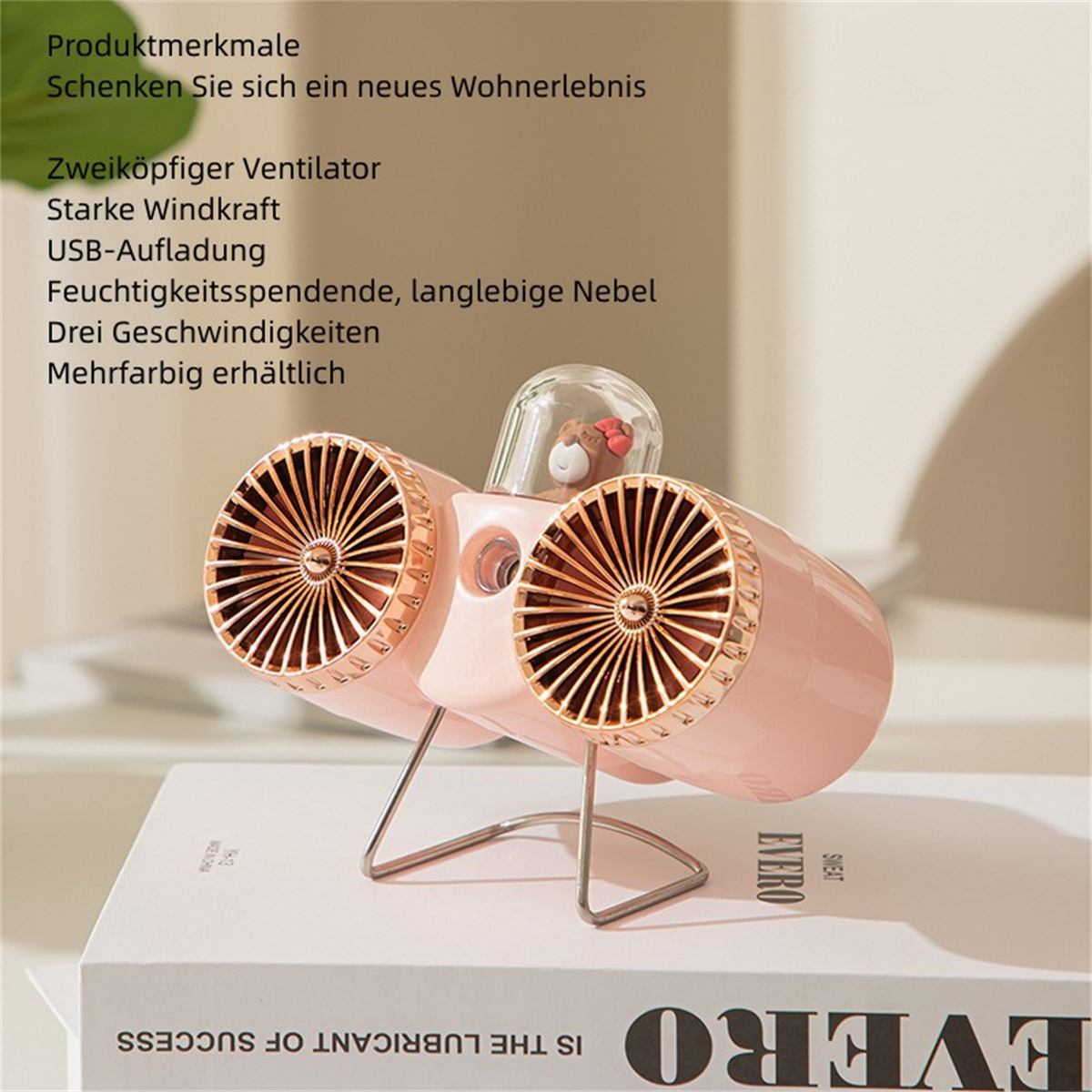 Ein rosa Tischventilator mit goldenen Akzenten und einer kleinen Bärenfigur.