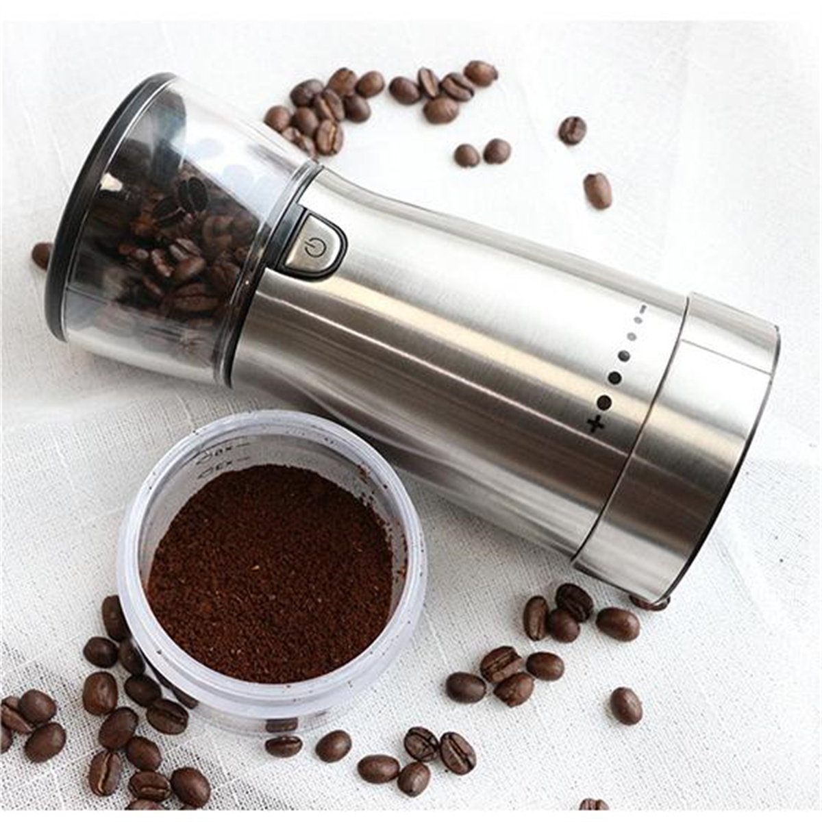 Elektrische Kaffeemühle mit Bohnen in der oberen Kammer und gemahlenem Kaffee in einem Behälter.