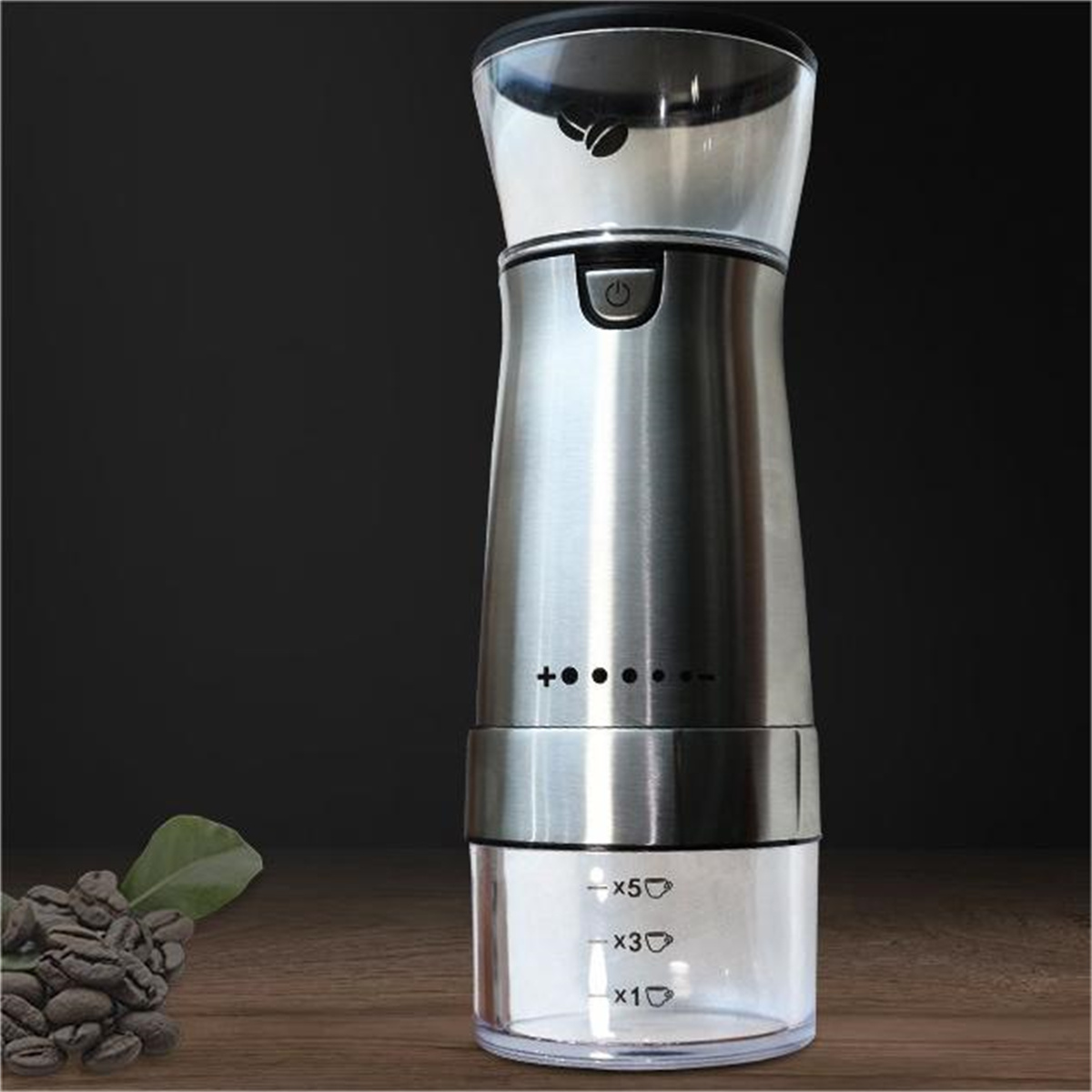 Silberne Kaffeemühle. Klarer oberer Behälter mit Kaffeebohnen. Schwarzer Hintergrund.