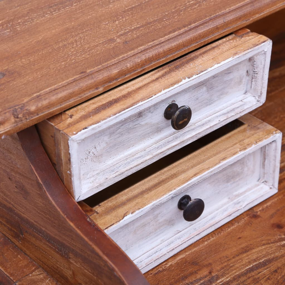 Holzschreibtisch mit zwei weißen Schubladen. Die Schubladen haben schwarze Knöpfe und liegen auf einer Holzoberfläche.