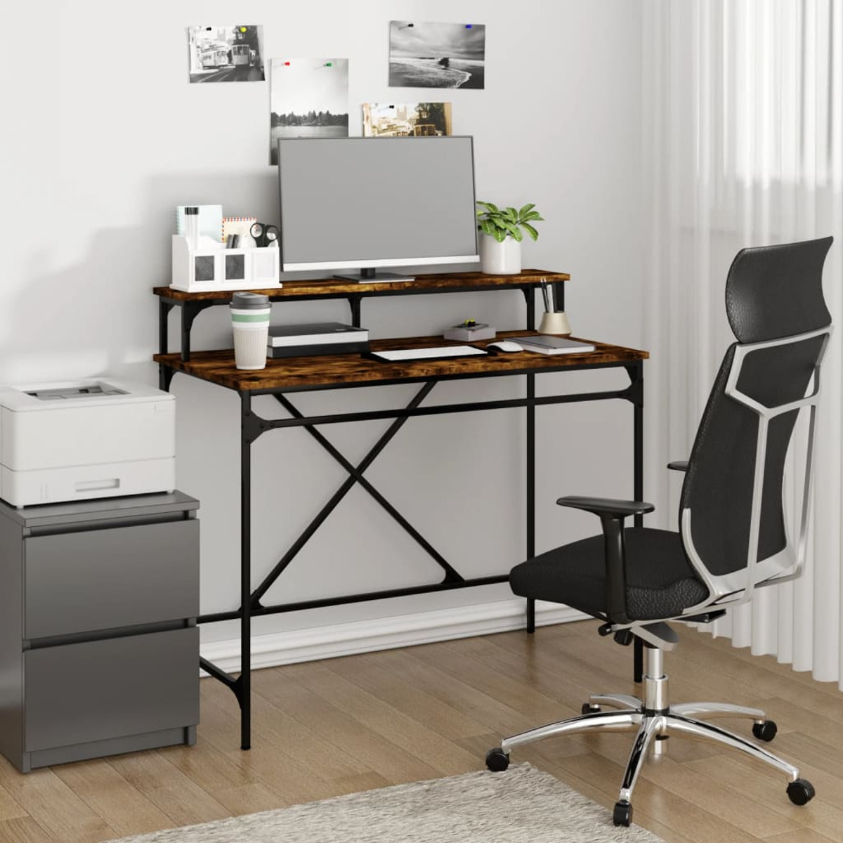 Ein Schreibtisch-Setup mit Computer, Monitor, Drucker und Stuhl. Der Schreibtisch steht vor einer weißen Wand.