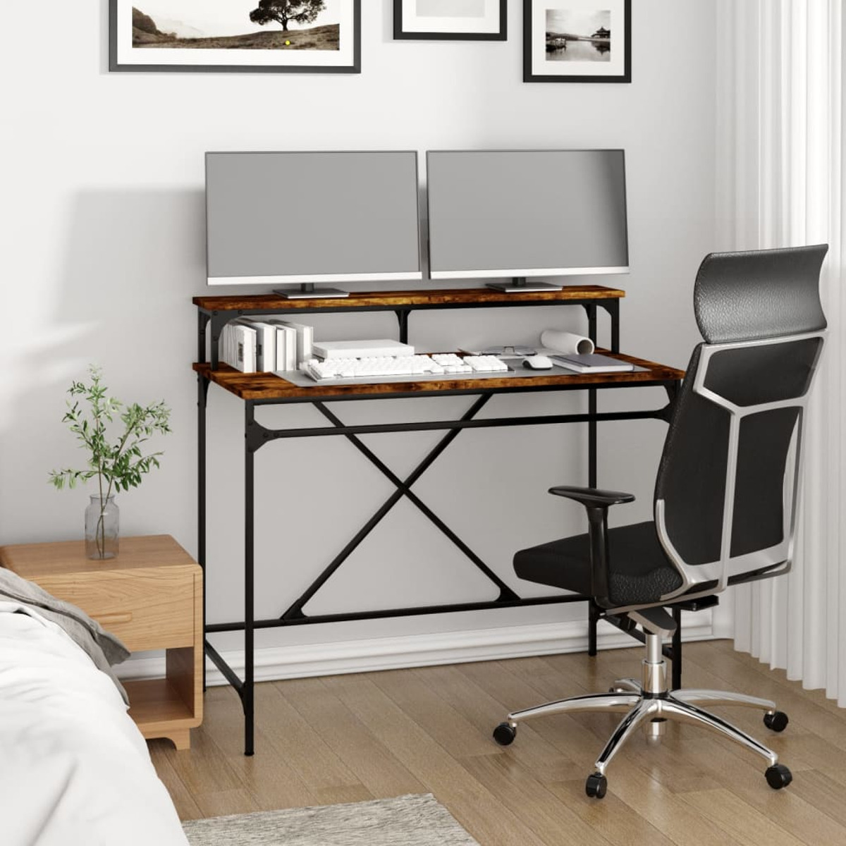 Schreibtisch mit zwei Monitoren, einer Tastatur und einem schwarzen Stuhl. Links ist eine Pflanze.