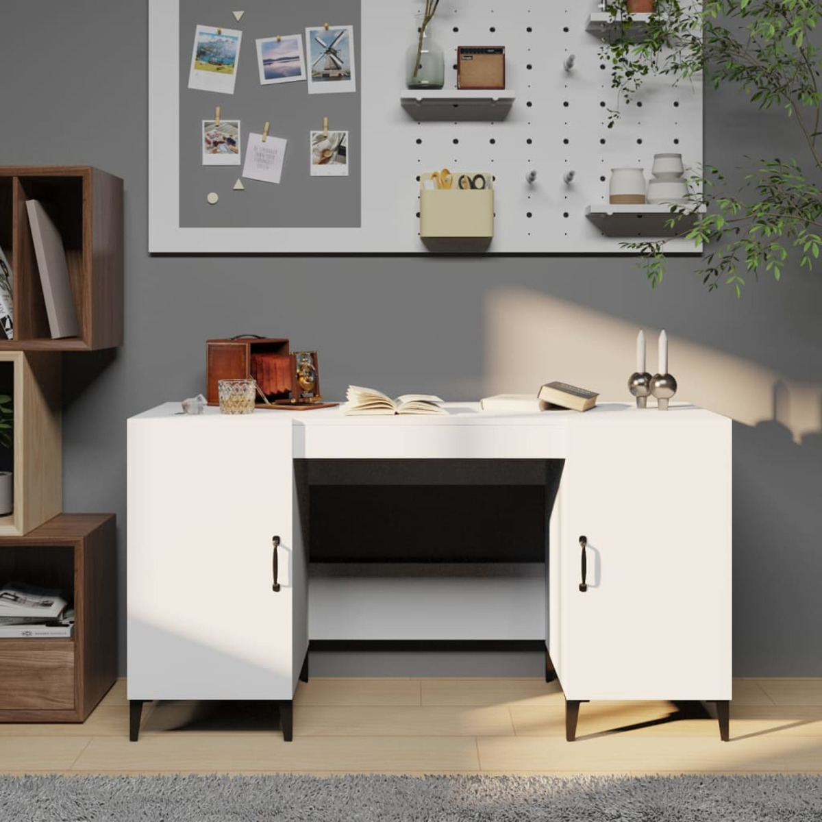 Weißer Schreibtisch mit Schranktüren, Büchern, Dekorationen und einer Lochwand im Hintergrund.