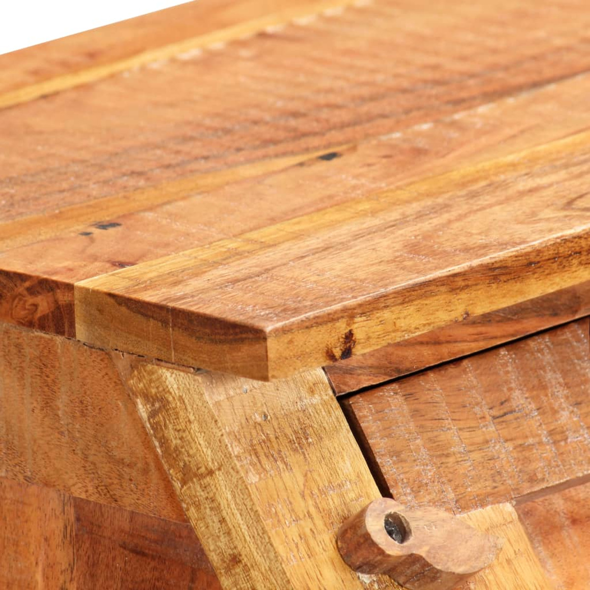Nahaufnahme einer Holztischkante. Sichtbar ist die Kante einer Schublade und ein Holzverschluss.