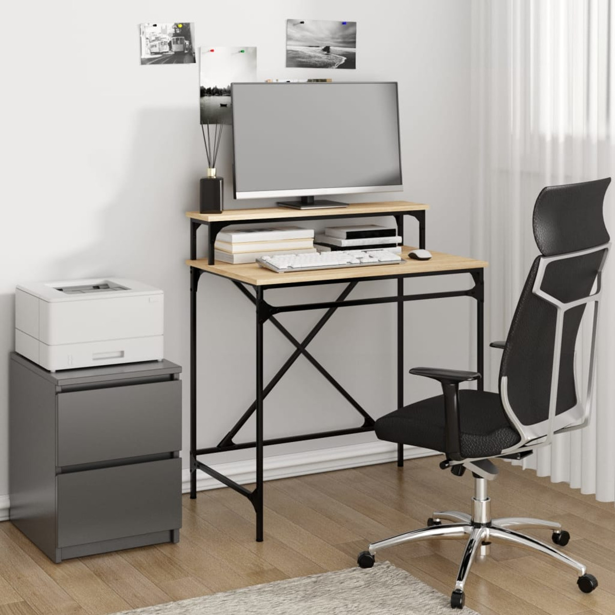 Ein Schreibtisch mit Monitor, Tastatur und Drucker. Ein schwarzer Stuhl davor.