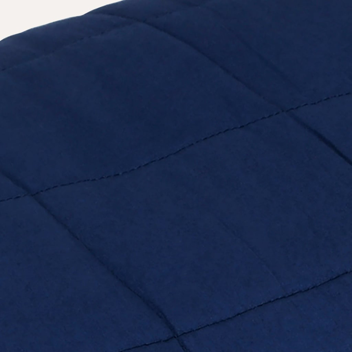 Nahaufnahme eines blauen, gesteppten Stoffes. Die Nähte erzeugen ein Gittermuster.