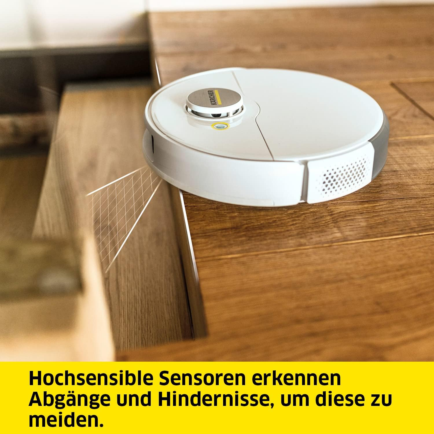 Biały odkurzacz automatyczny na drewnianej podłodze. Tekst: Czujniki omijają przeszkody.