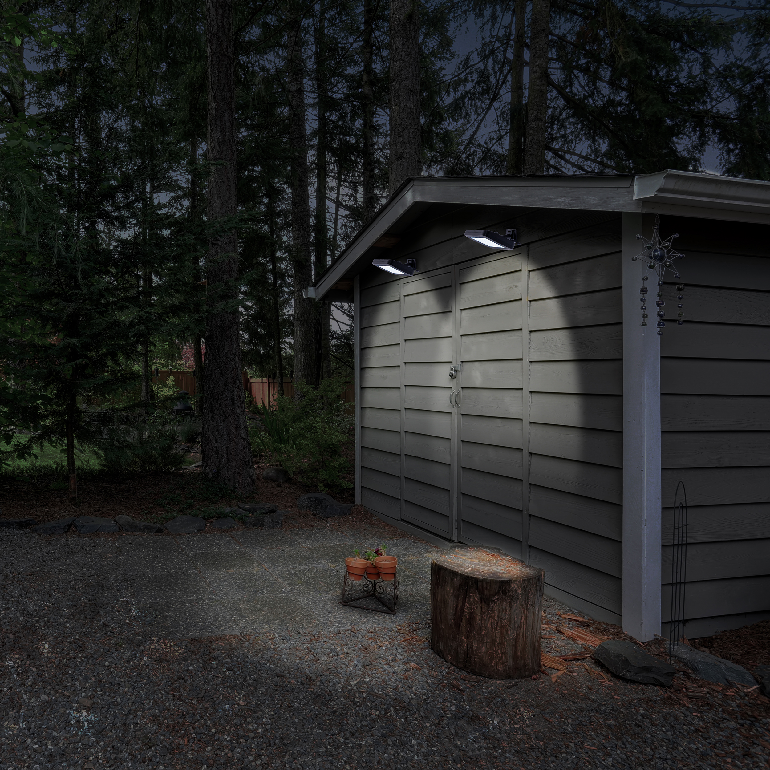 Ein Schuppen mit Lichtern, ein Baumstumpf und Bäume im Hintergrund bei Dämmerung.