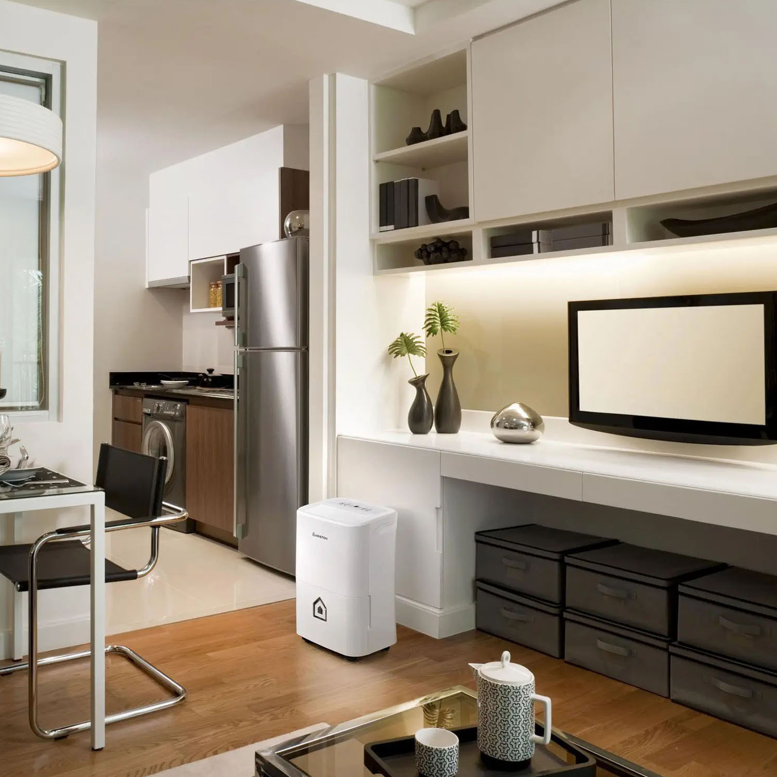 Salón moderno con un deshumidificador. Incluye muebles, decoración, cocina y un marco de puerta abierto.