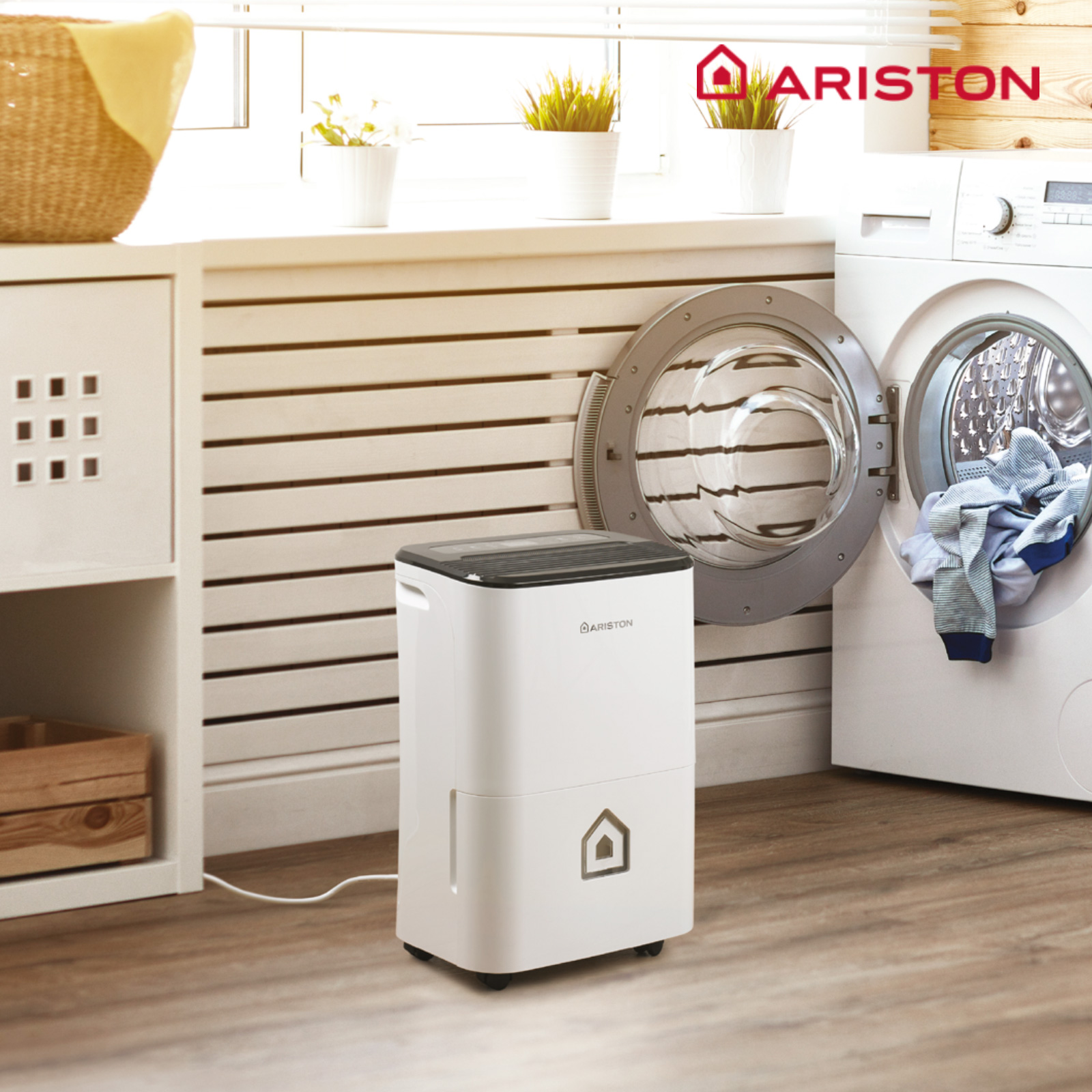 Deshumidificador blanco en una habitación con lavadora y logo Ariston.